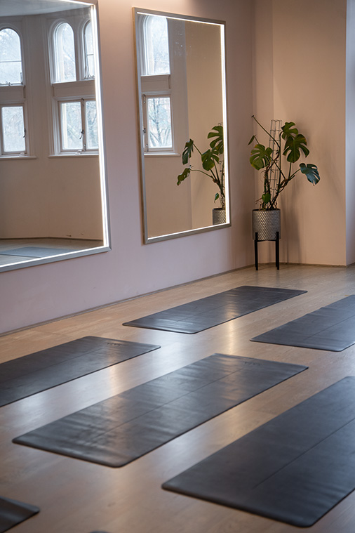Serene yoga studio with mirrored walls, perfect for wellness retreats and team-building events.