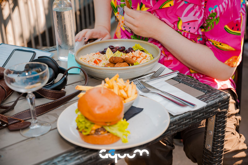 Vibrant dining setup with burgers and fries for casual networking events at Aquum.