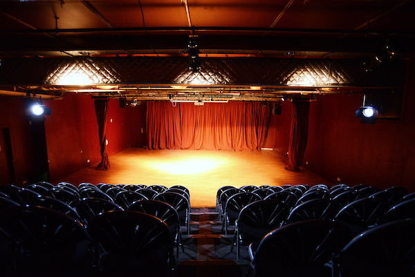 Theatre in Oxford House with red curtains, ideal for workshops and performances.