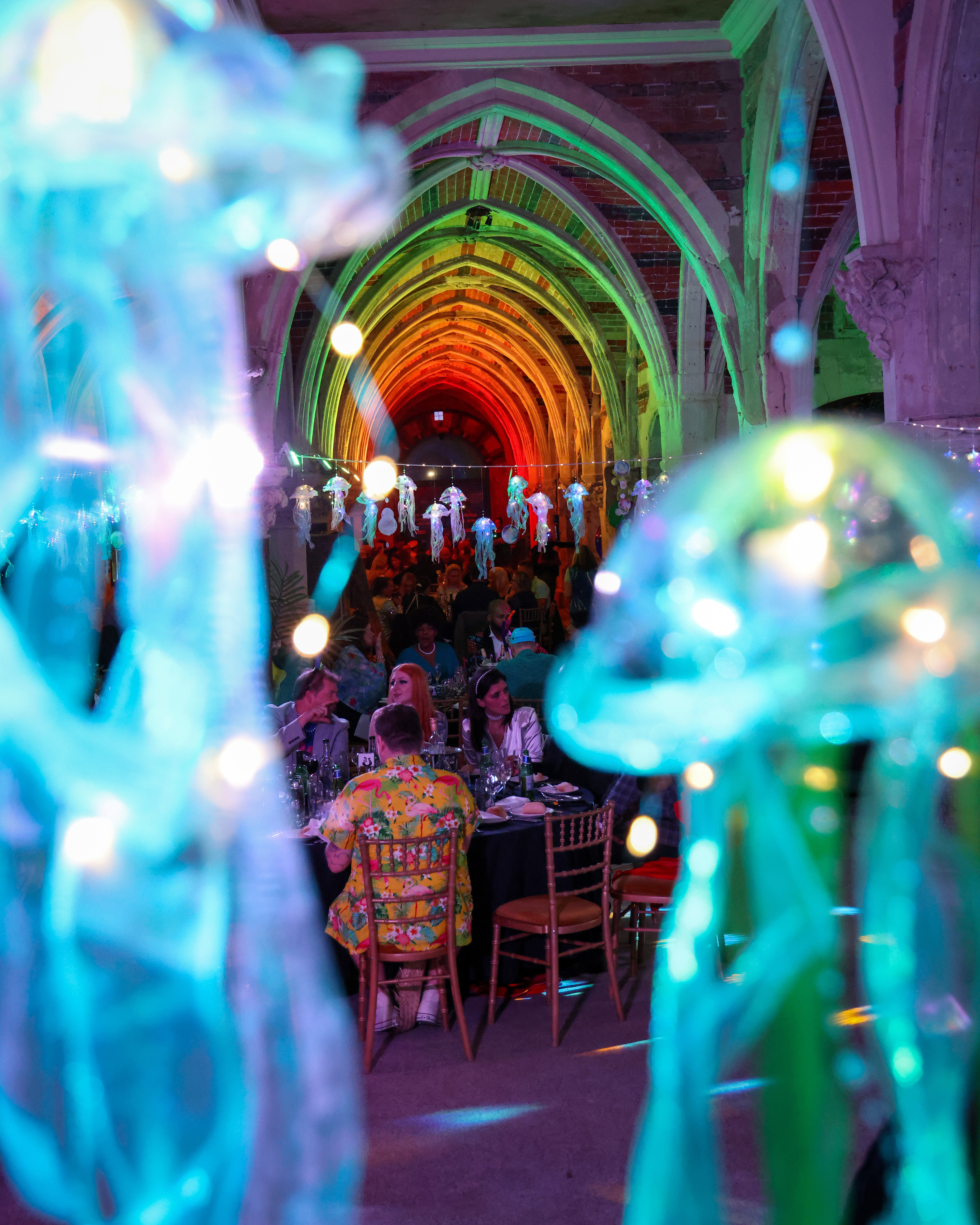 Vibrant event space at SEA LIFE Brighton Aquarium with colorful lighting and elegant tables.