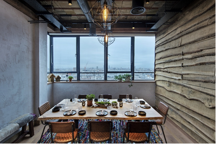 Stylish meeting space with wooden table and city view at The Treehouse Hotel.