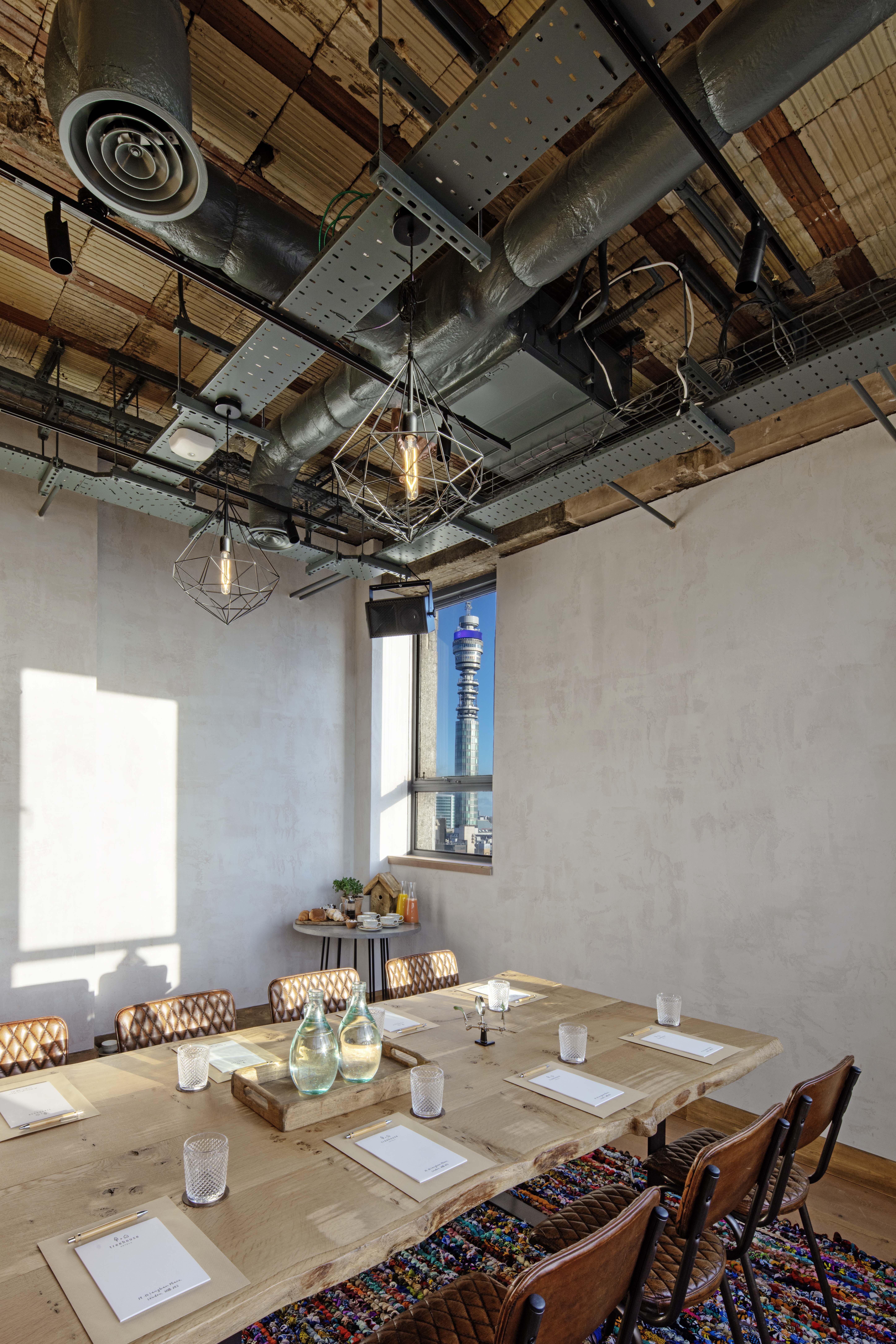 Modern meeting space in The Treehouse Hotel with industrial design and panoramic views.