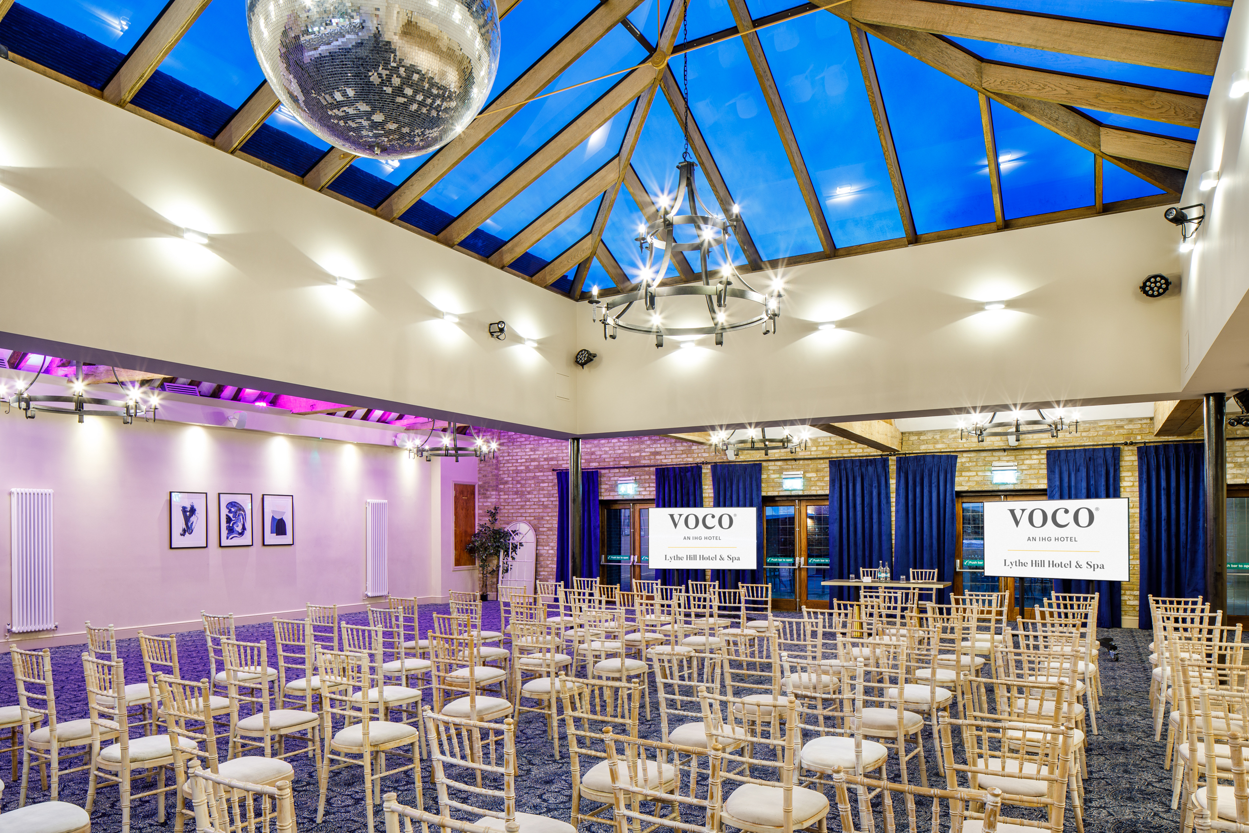 Hazel Suite at Voco Lythe Hill: elegant event space with wooden beams, ideal for conferences.