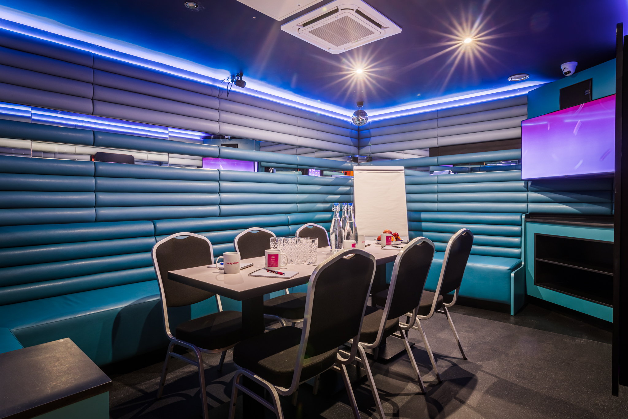 Private karaoke room with turquoise seating, perfect for meetings and workshops.