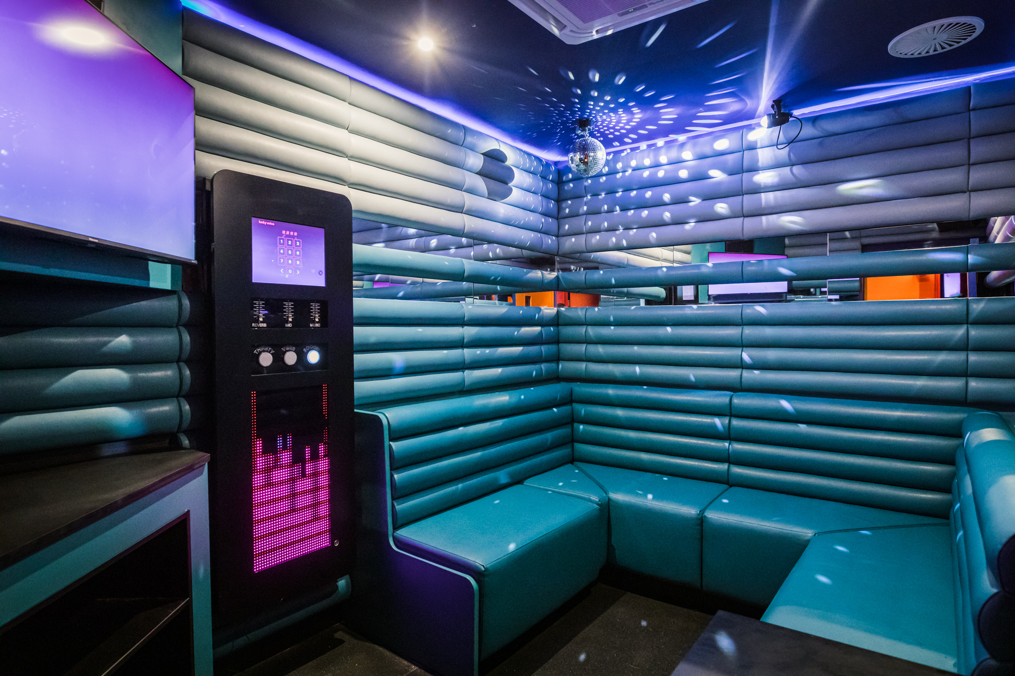 Vibrant private karaoke room with sleek seating for team-building events in Liverpool.