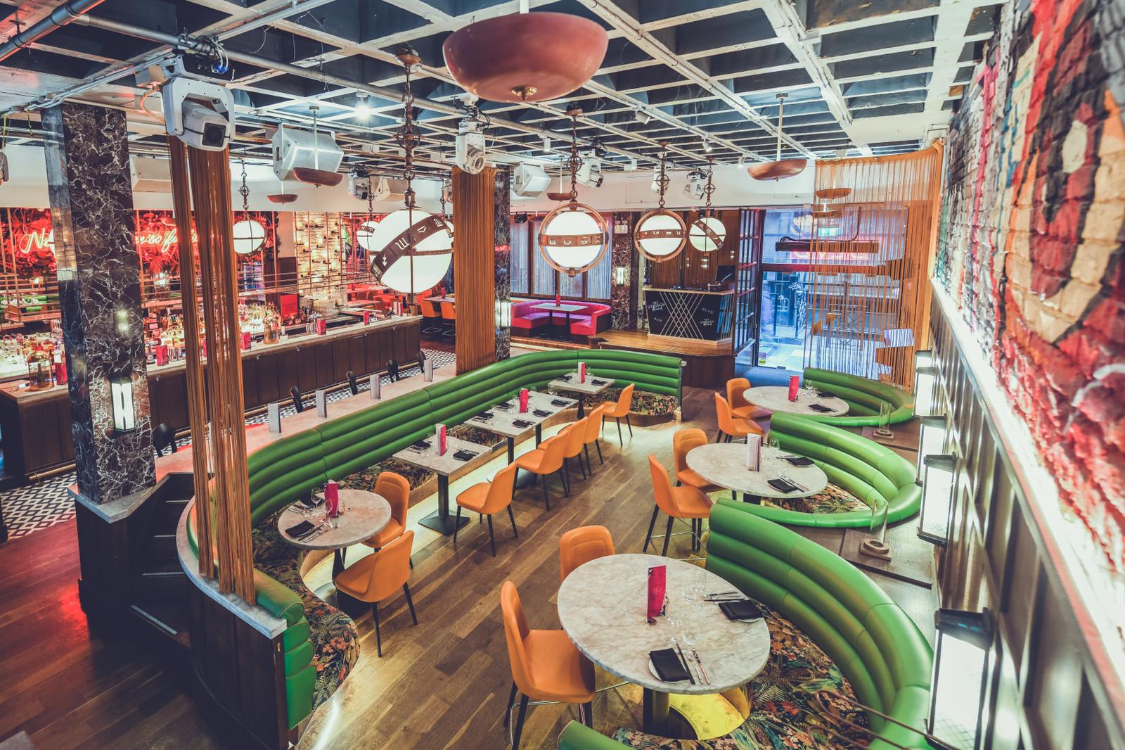 Modern event space with green booths, ideal for networking and casual meetings.