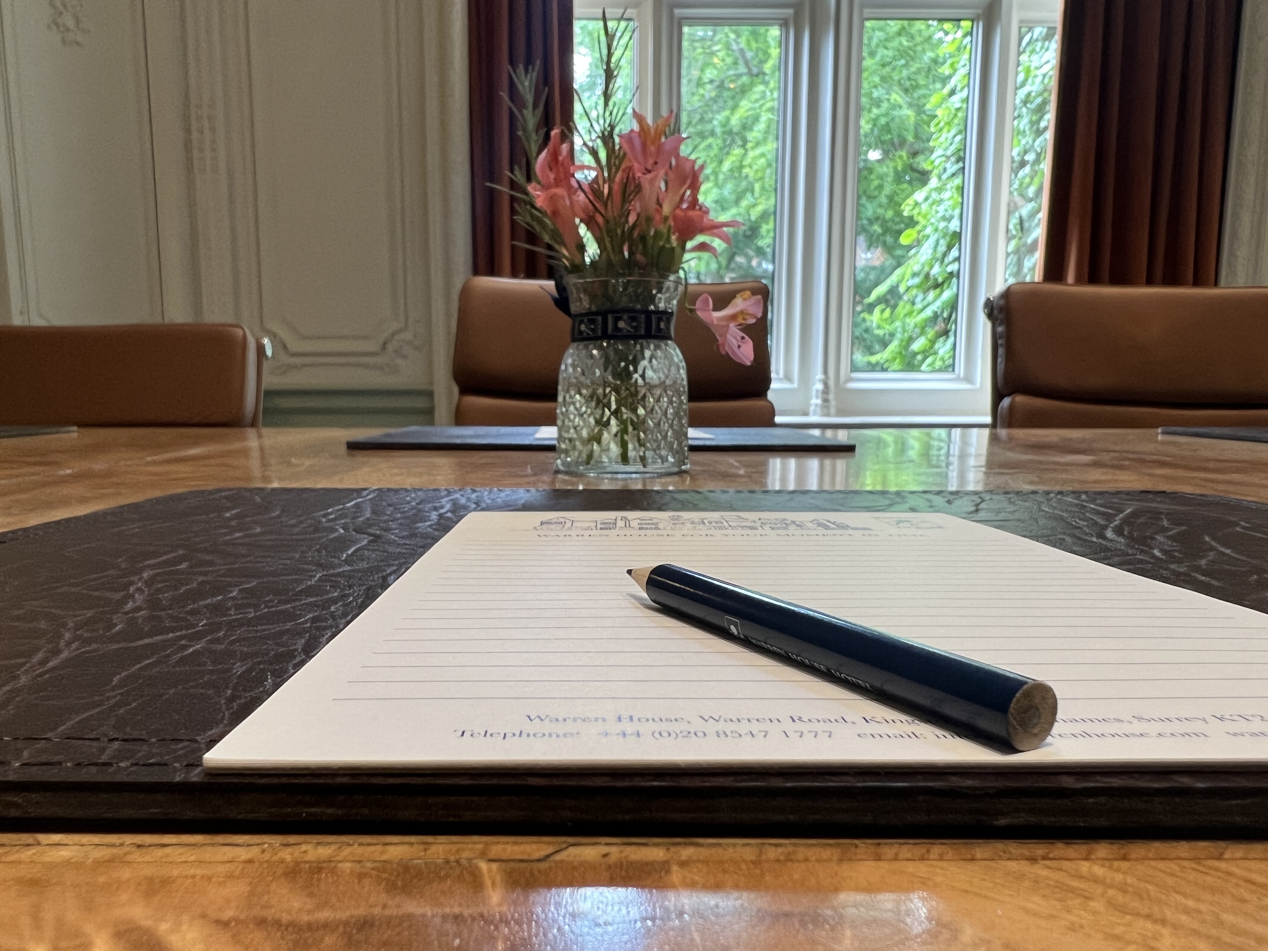 Lavender meeting space at Warren House Hotel with polished table and floral centerpiece.
