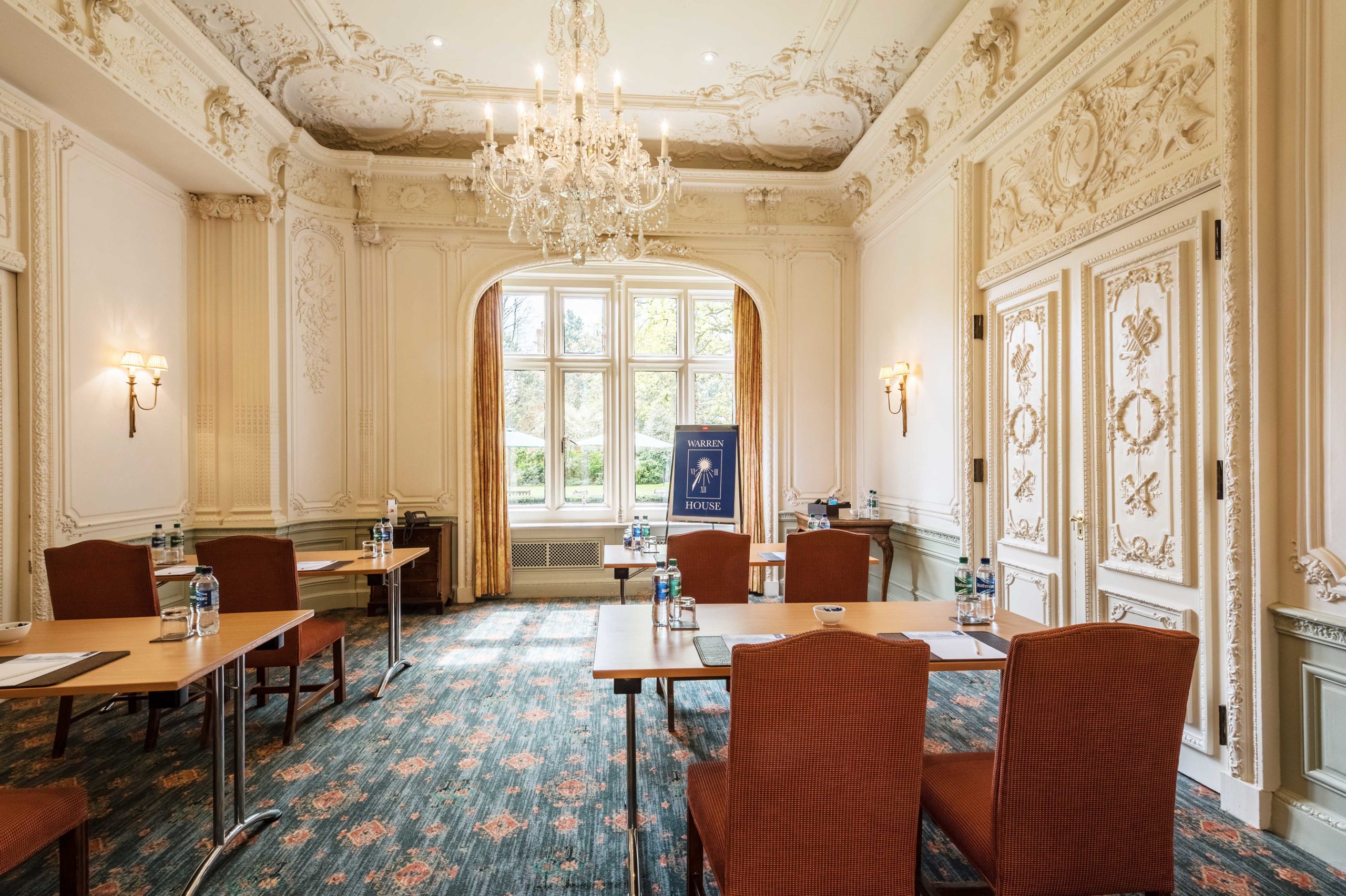Elegant meeting room with chandelier at Warren House Hotel, ideal for corporate events.
