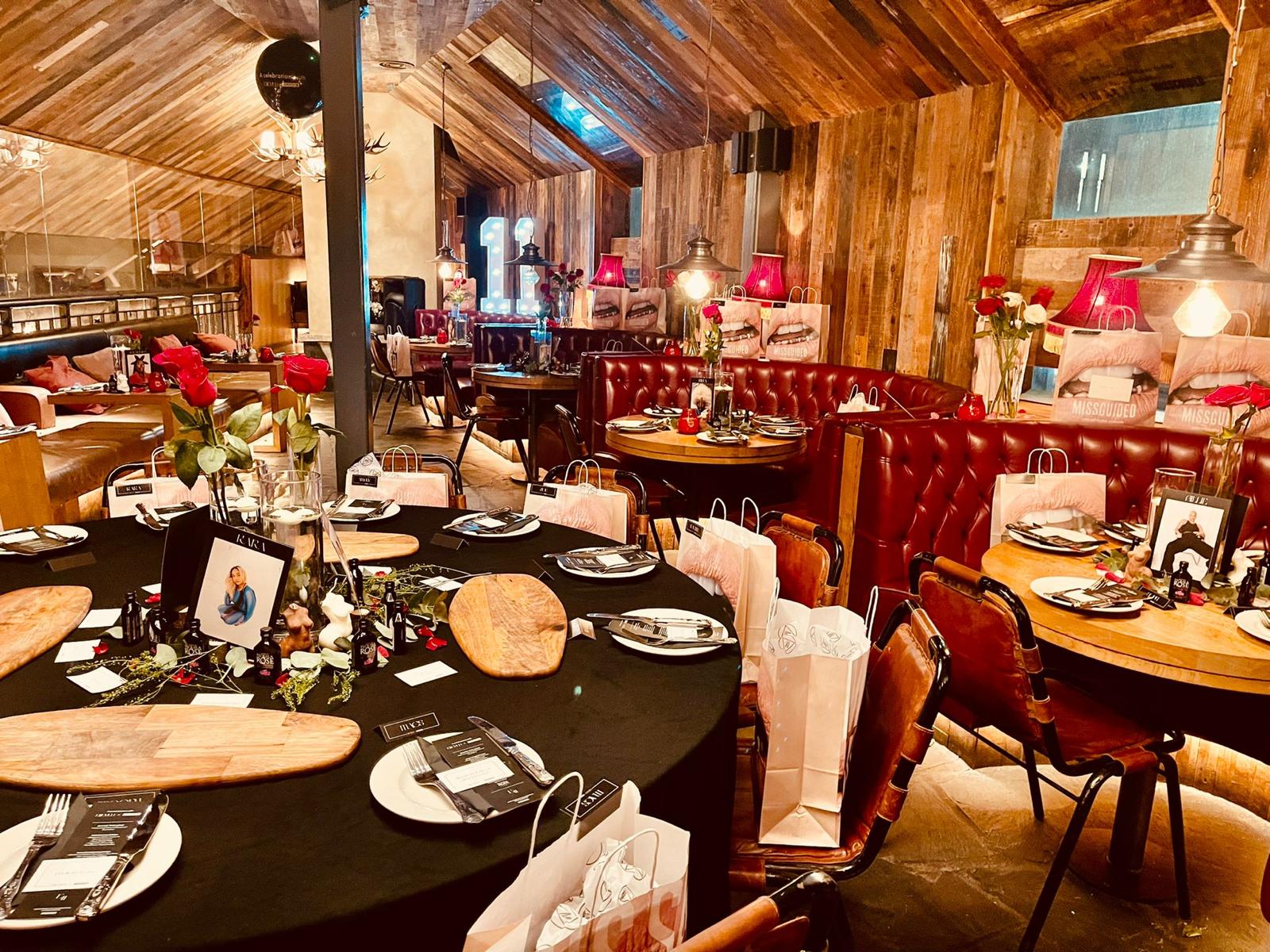 Elegant event space at Gin Nest, Manchester with round tables and ambient lighting.