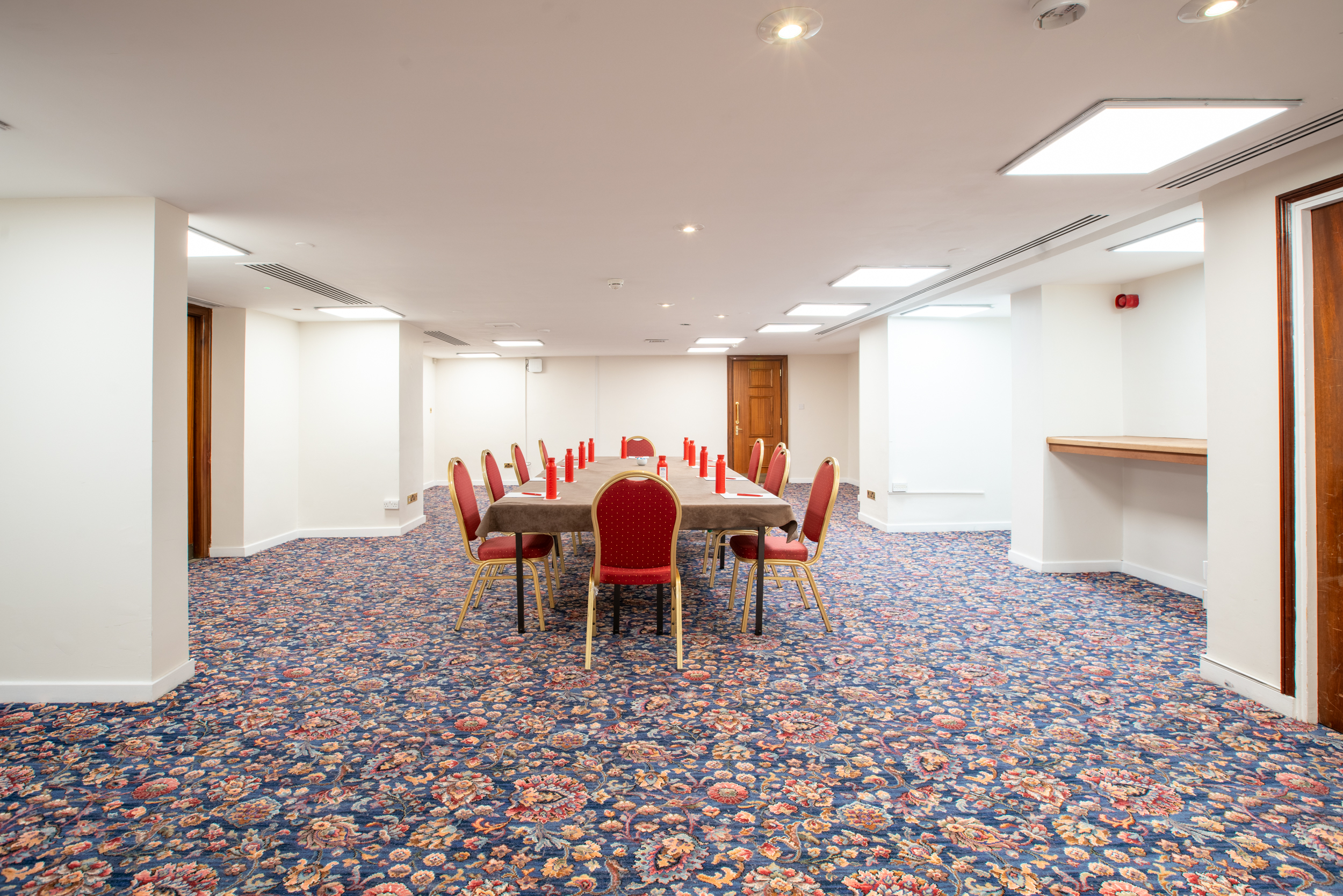 Cromwell 6 meeting space in Kensington with elegant red chairs for corporate events.