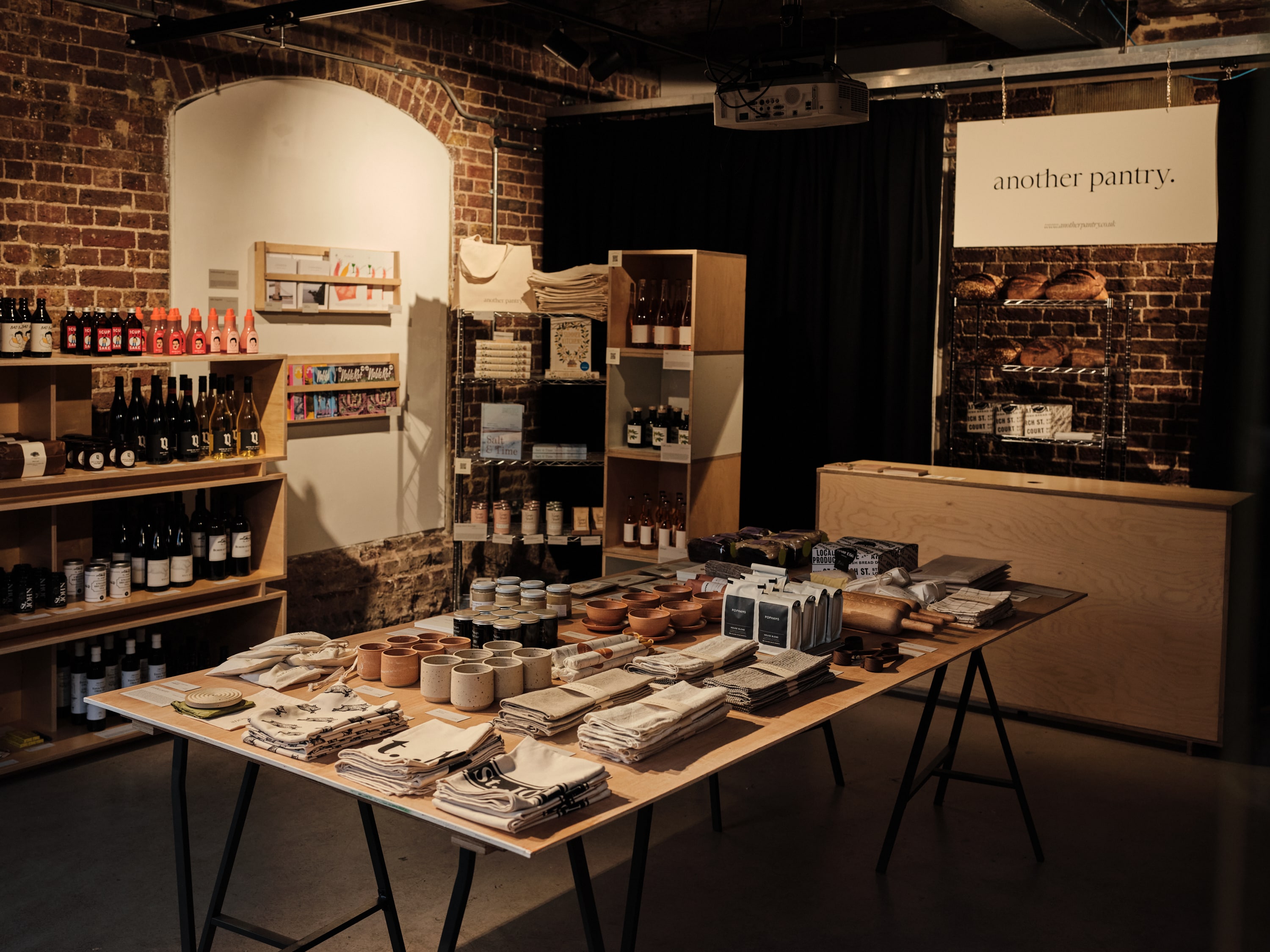 Artisanal pop-up market at Kiosk N1C with rustic brick backdrop and curated displays.