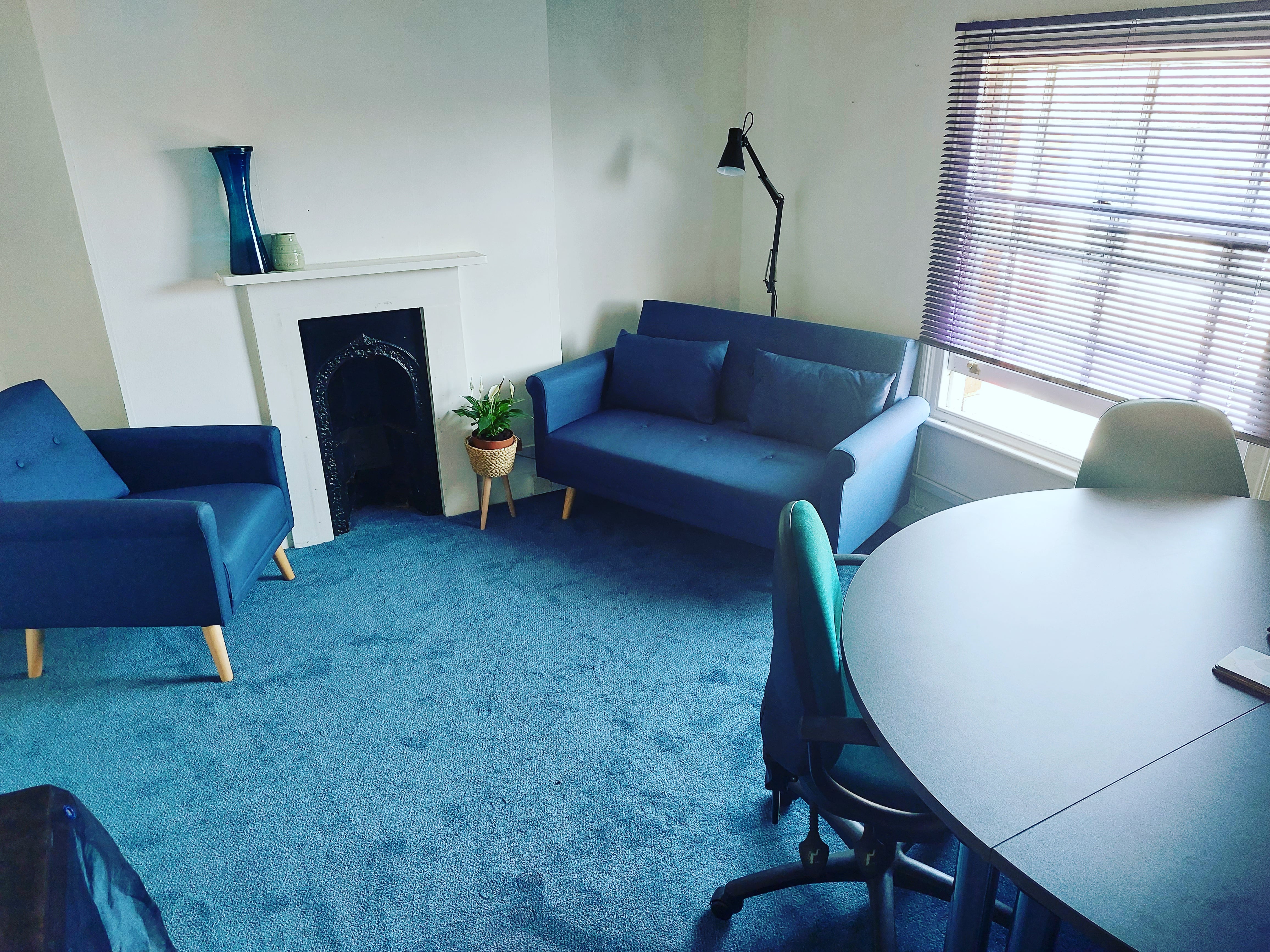 Cozy meeting space with blue furnishings for intimate gatherings and brainstorming sessions.