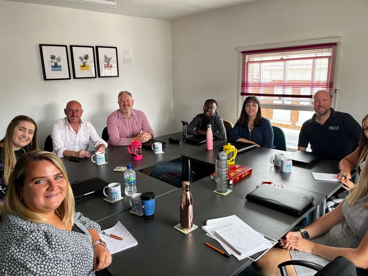 Diverse professionals in a modern conference room for event planning meeting.