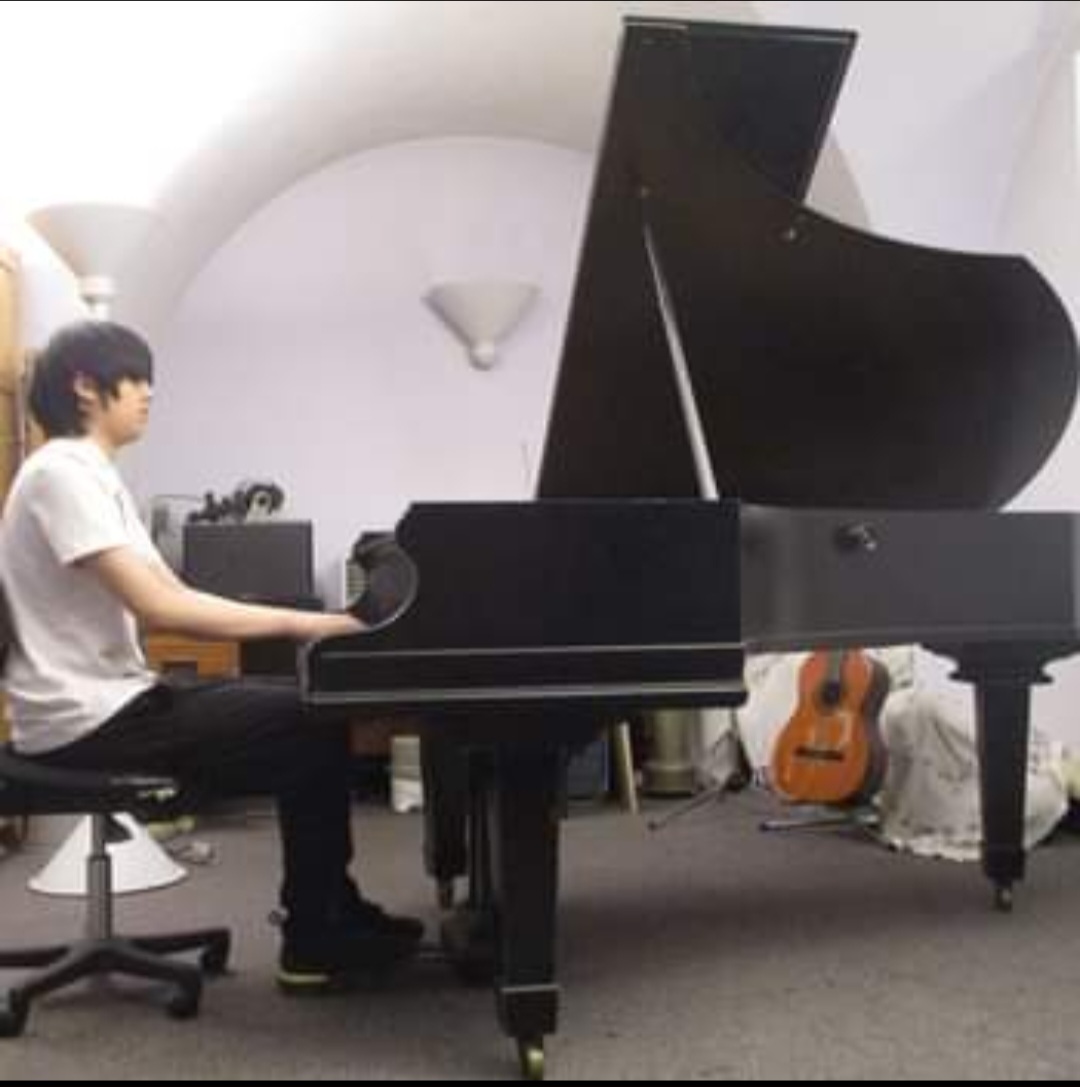 Young musician playing grand piano at Pepys Community Hub for live entertainment event.