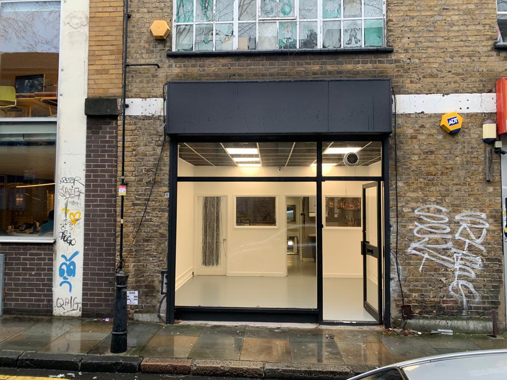 Modern art gallery with glass front, ideal for events and workshops in urban setting.