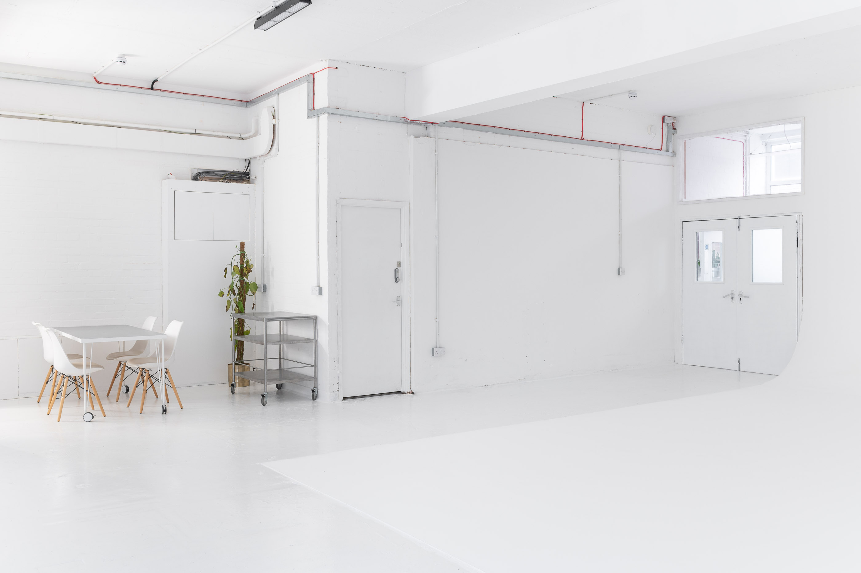 Versatile minimalist event space with bright walls for meetings and workshops.