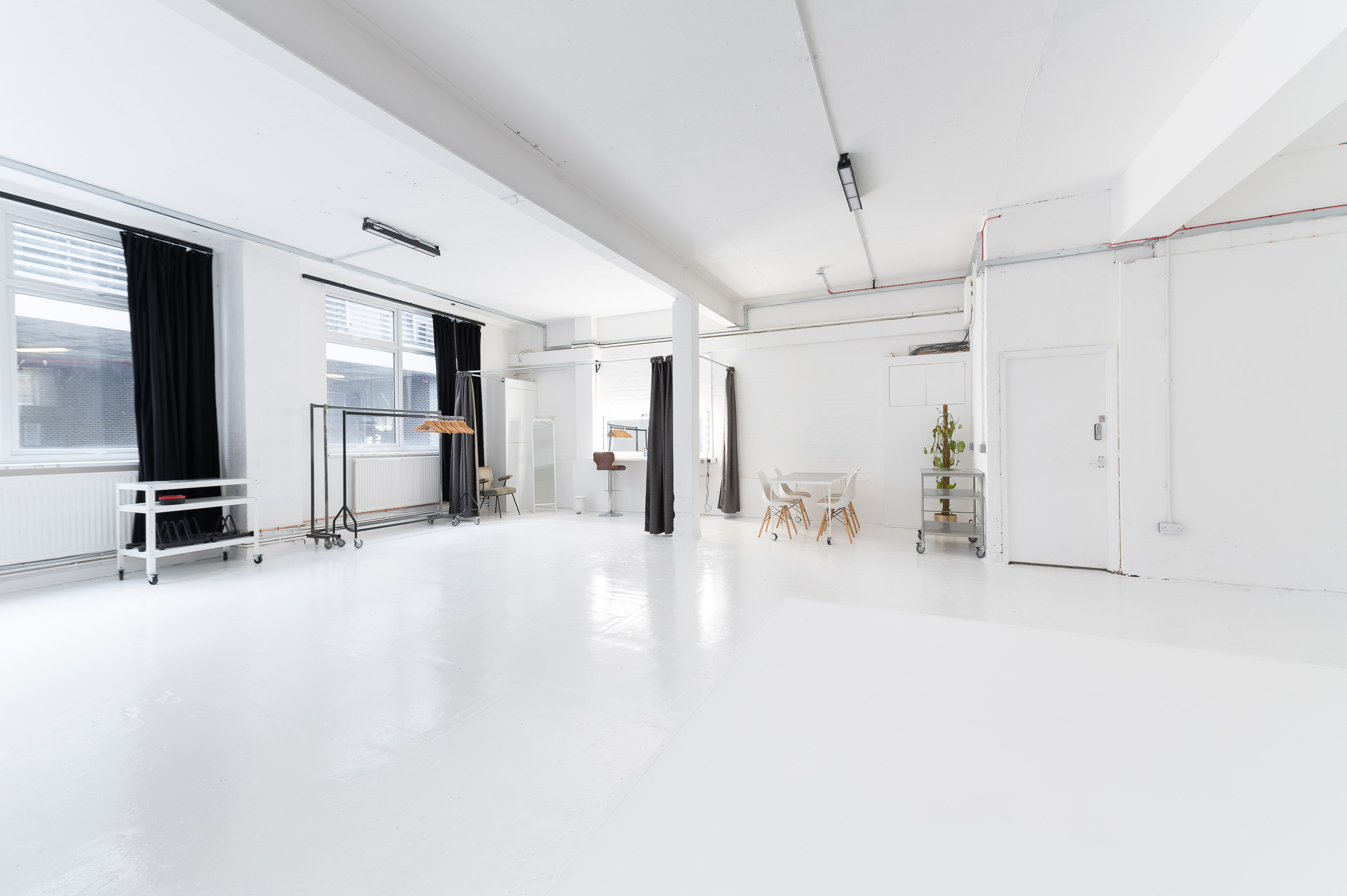 Versatile minimalist event space with natural light for meetings and workshops.