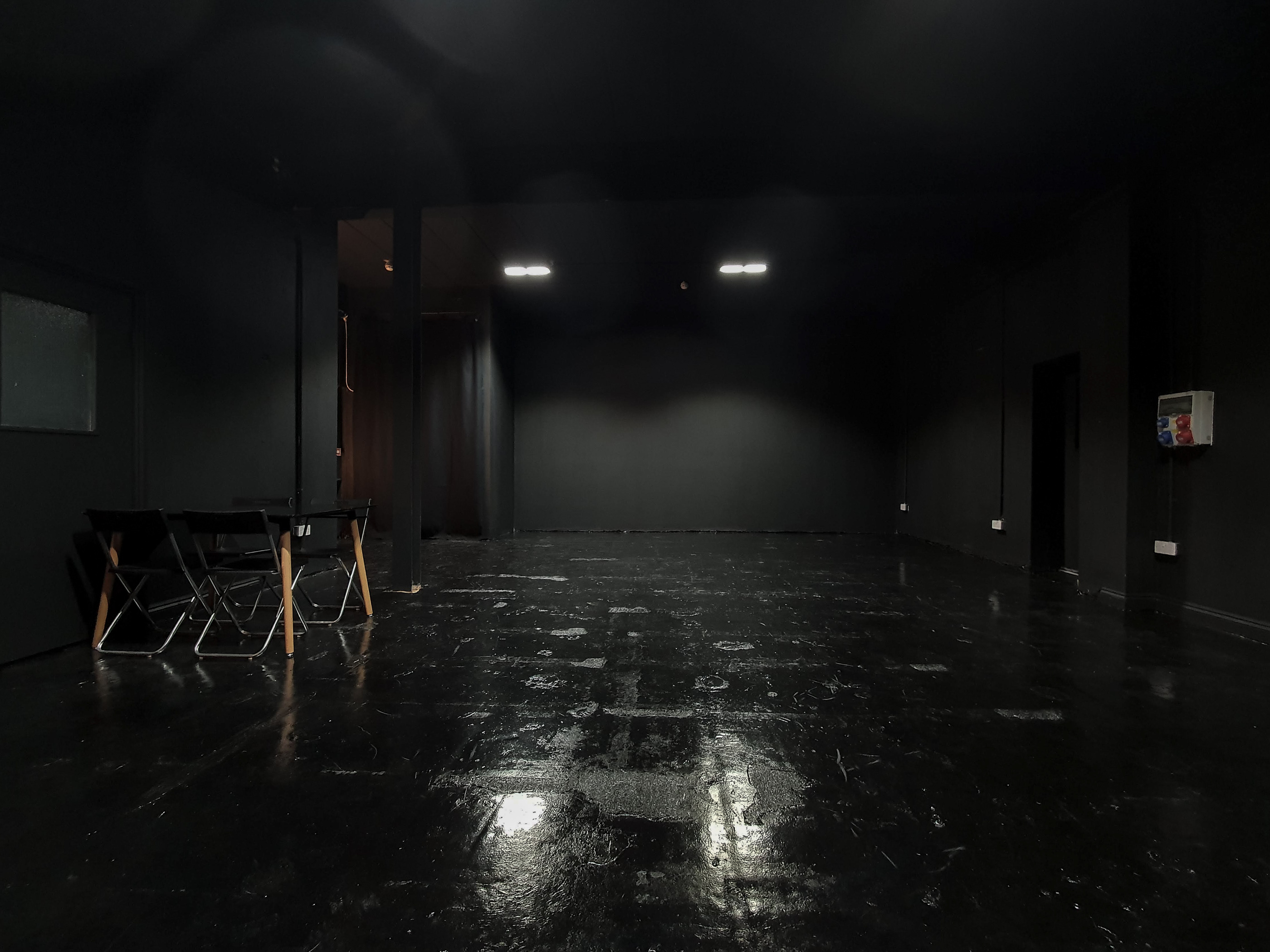 Versatile minimalist event space with sleek black interior for meetings and workshops.