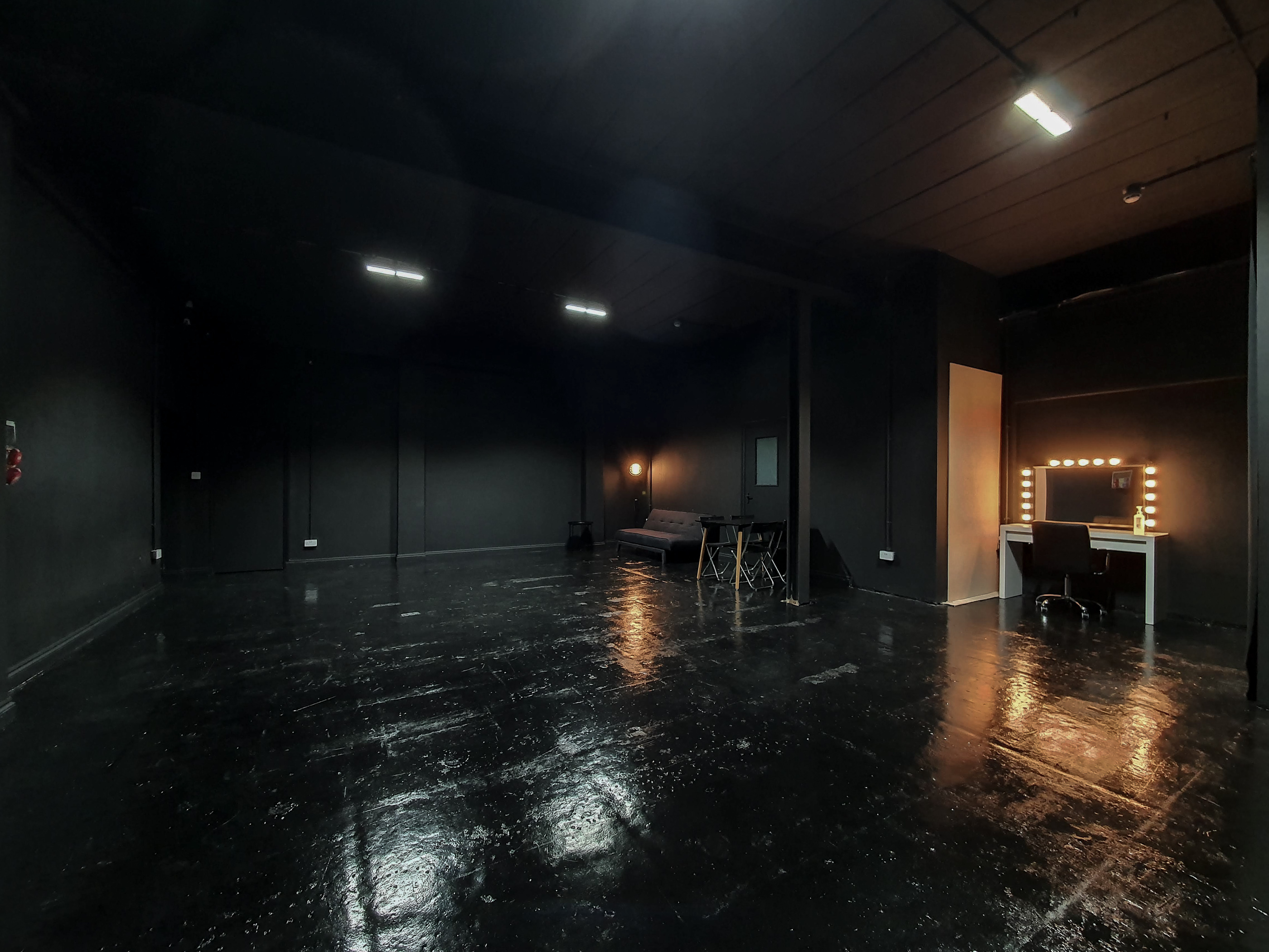 Versatile event space with dark walls, ideal for creative meetings and private events.