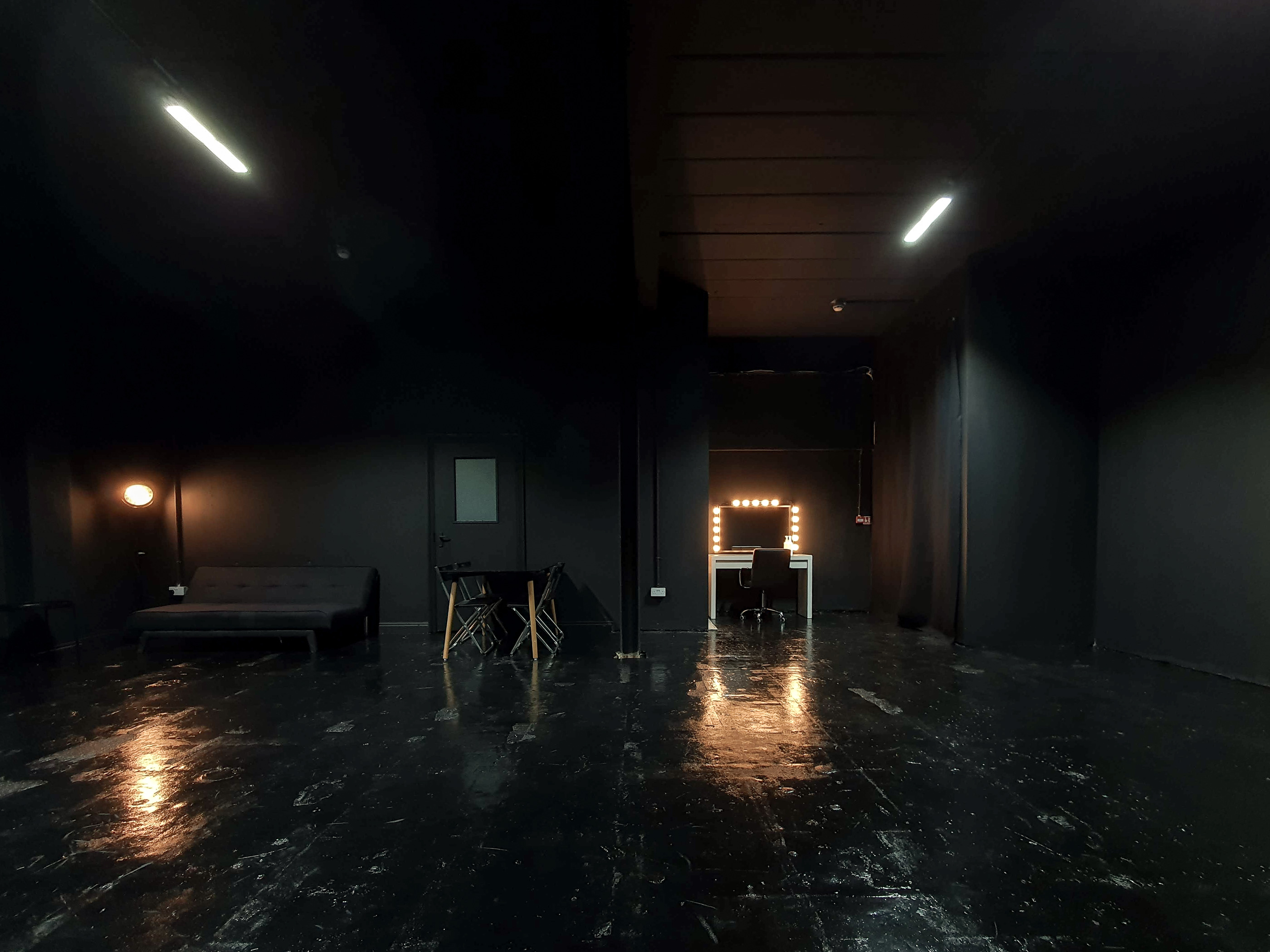 Versatile event space with dark walls and polished floors at 69 Drops Studios.