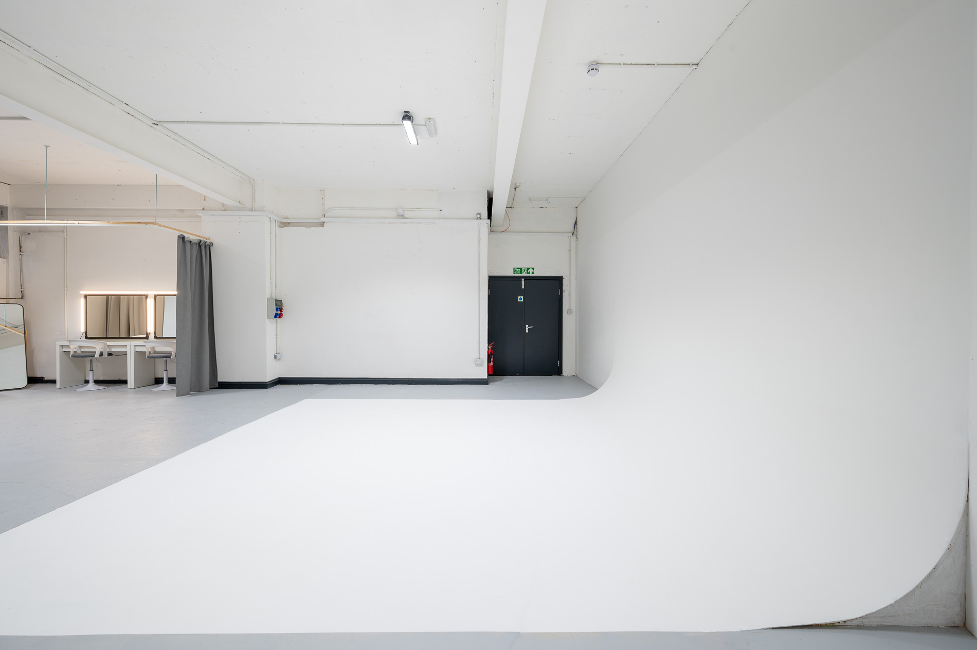 Versatile blank canvas event space with clean white backdrop for meetings and workshops.