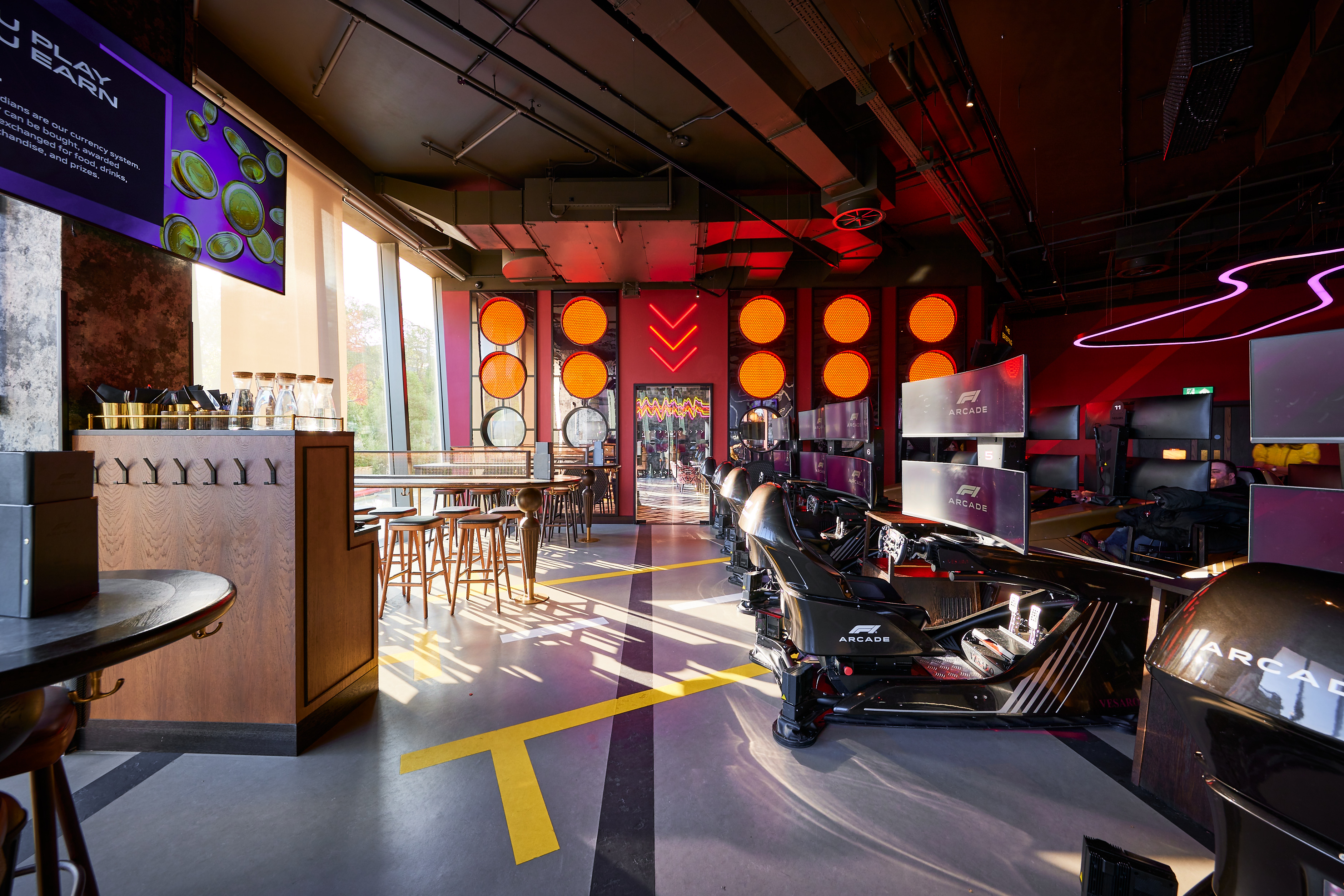 Vibrant F1 Arcade event space with sleek racing simulators for corporate gatherings.