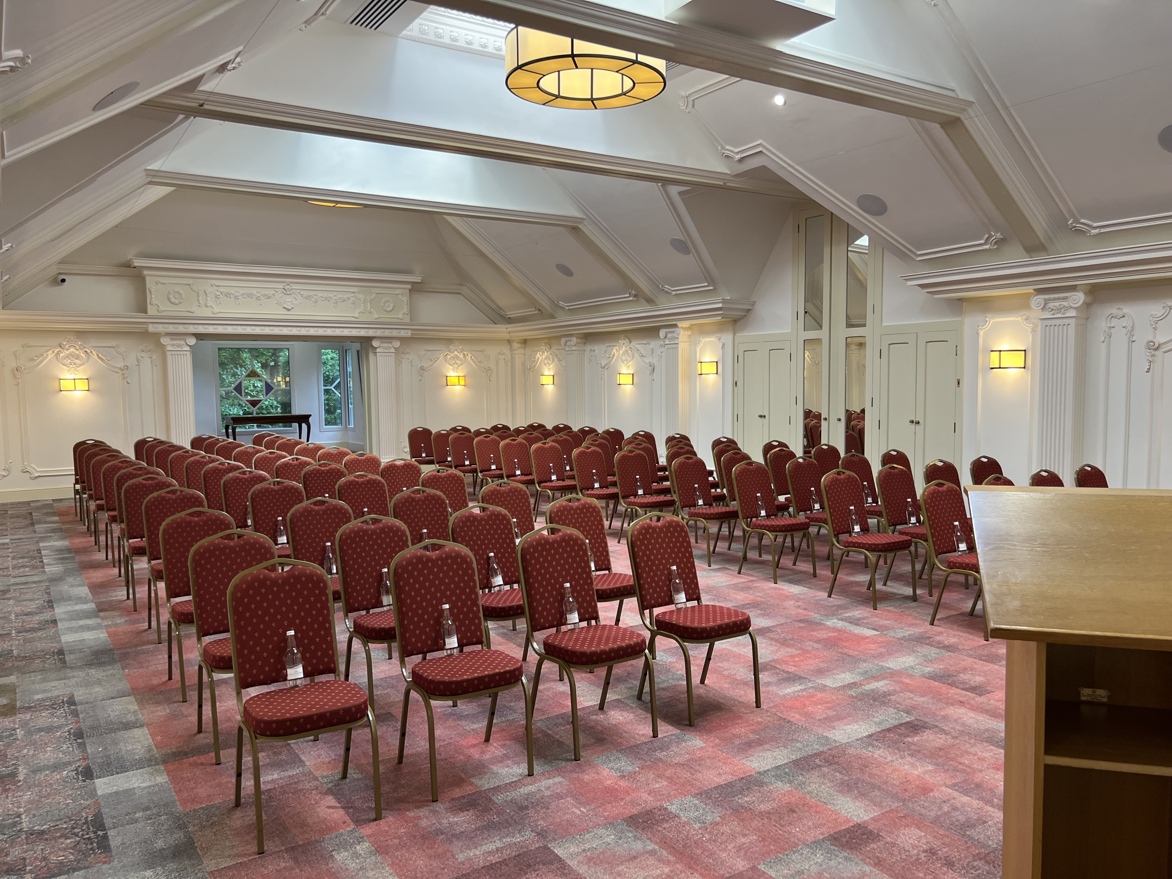 London Room at Warren House Hotel, set for a conference with red chairs and ample lighting.