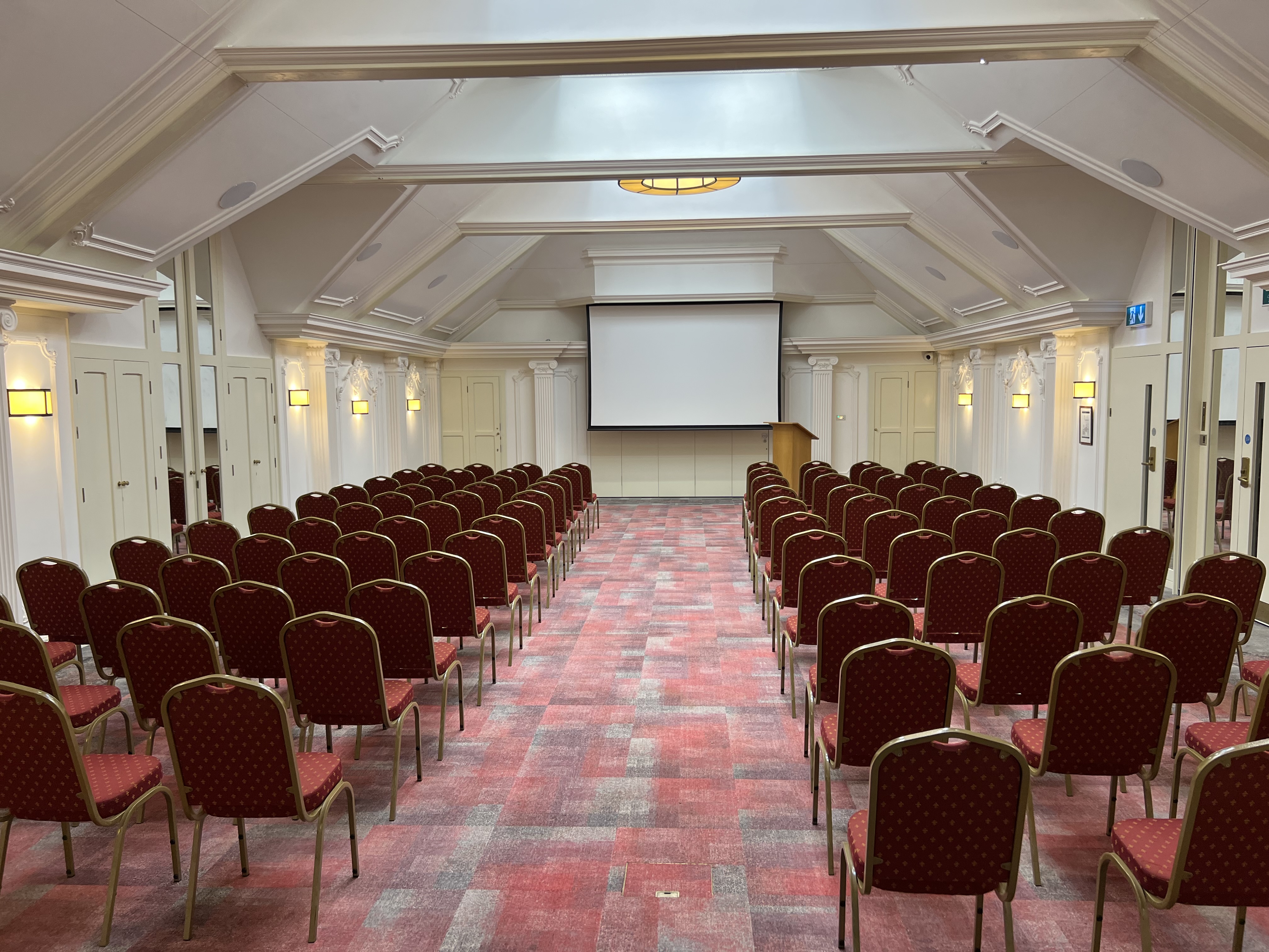 London Room at Warren House Hotel with red chairs, perfect for conferences and workshops.