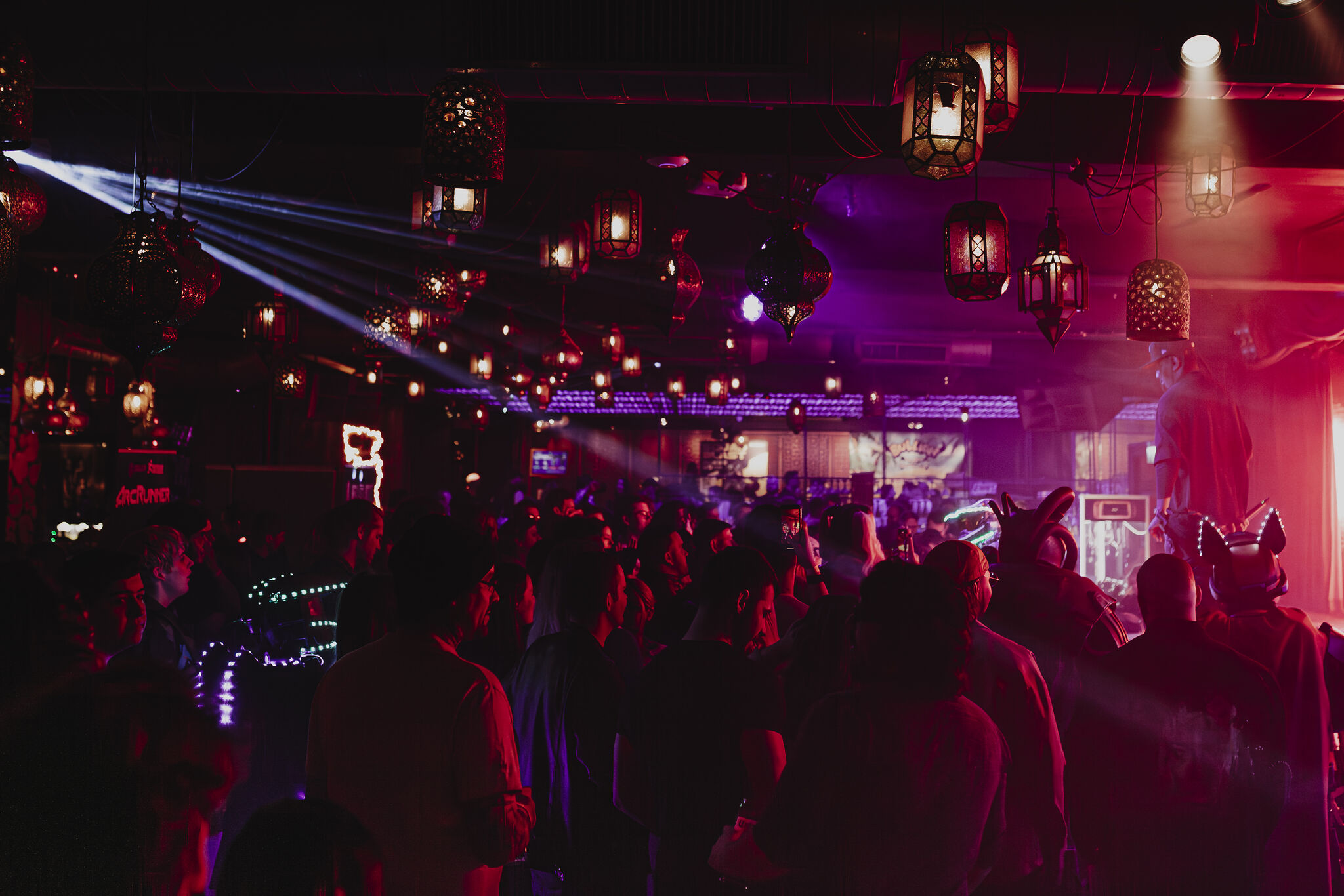 Vibrant Impossible Theatre event space in Manchester with colorful lighting and lively crowd.