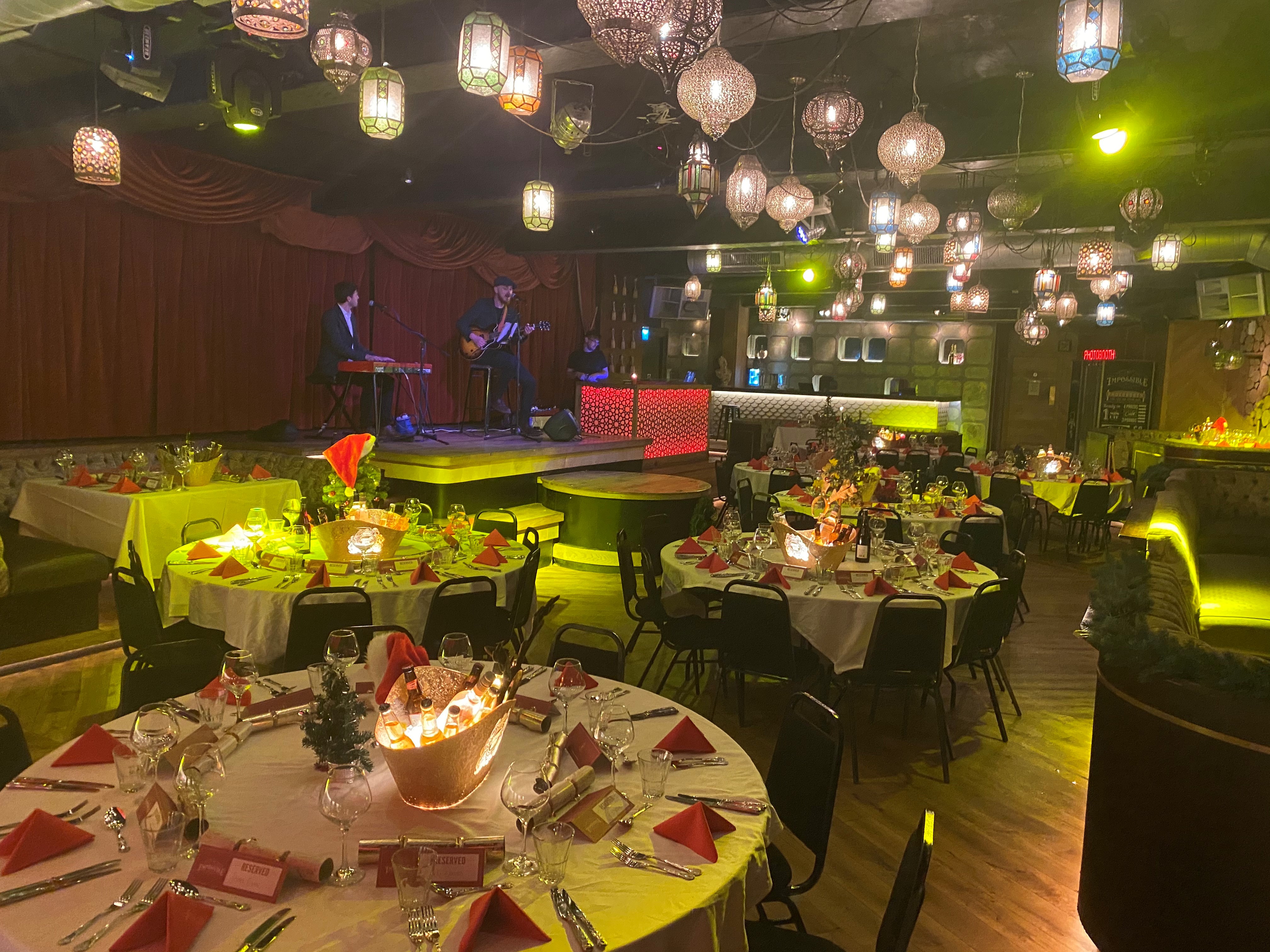 Elegant dinner setup at Impossible Theatre, Manchester with festive decor and live music.
