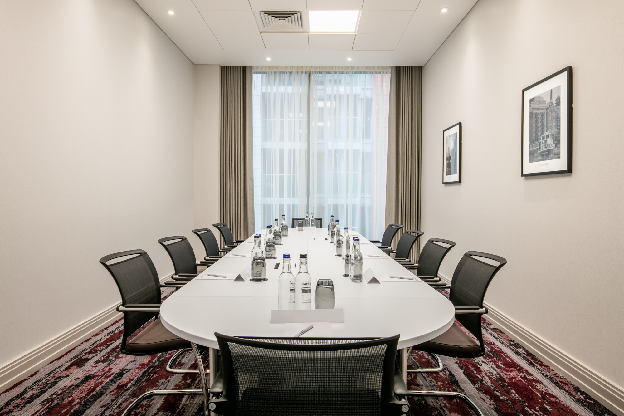 Modern Manhattan Suite meeting room with oval table, ideal for corporate events.