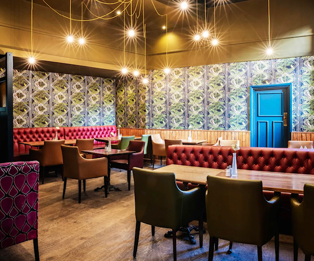 Stylish event space at Auberge London with vibrant wallpaper, ideal for gatherings.