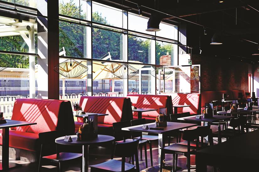 Gasworks Kitchen at Southampton FC: modern dining with red booths, perfect for networking events.