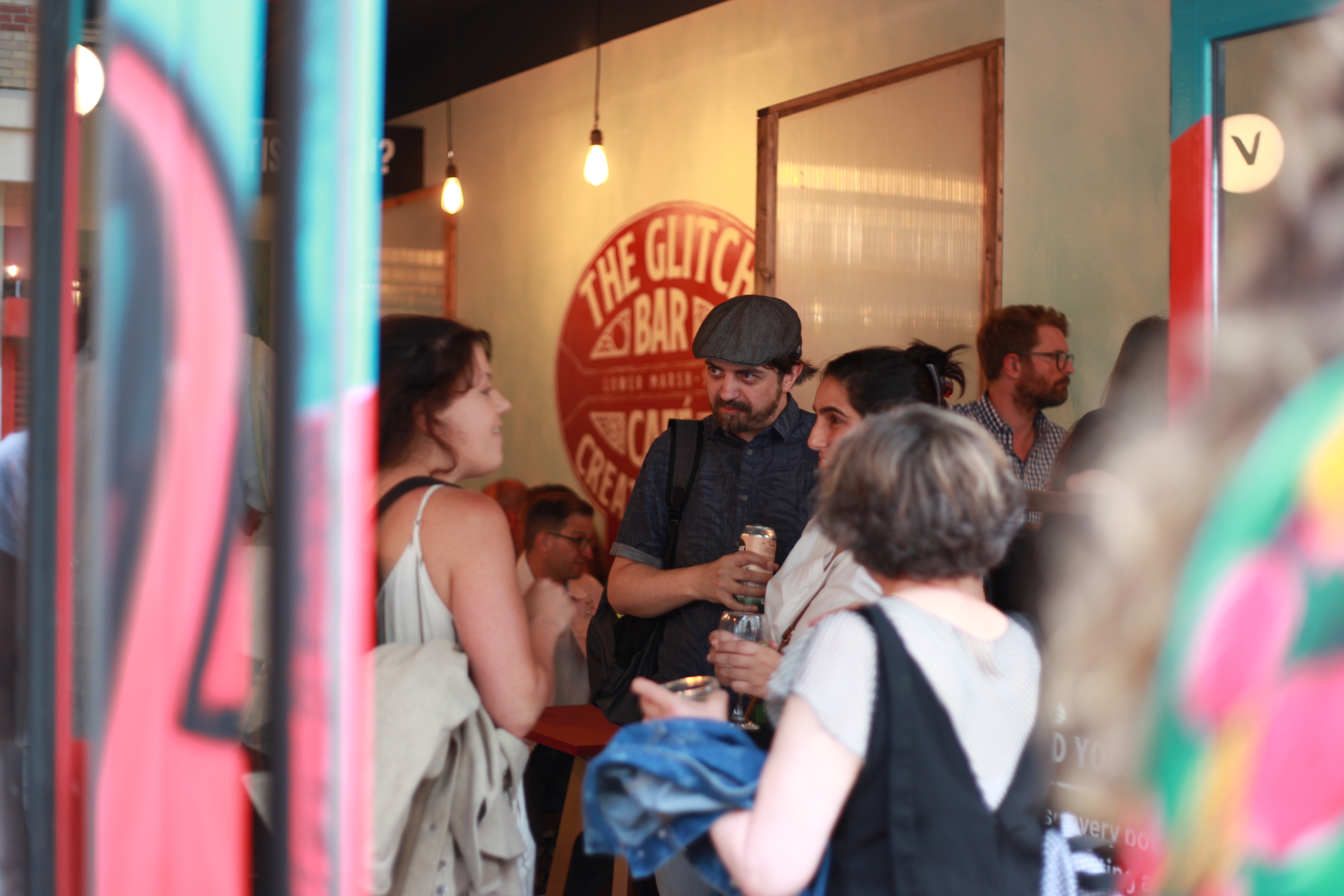 Vibrant networking event at The Glitch bar with colorful decor and warm lighting.