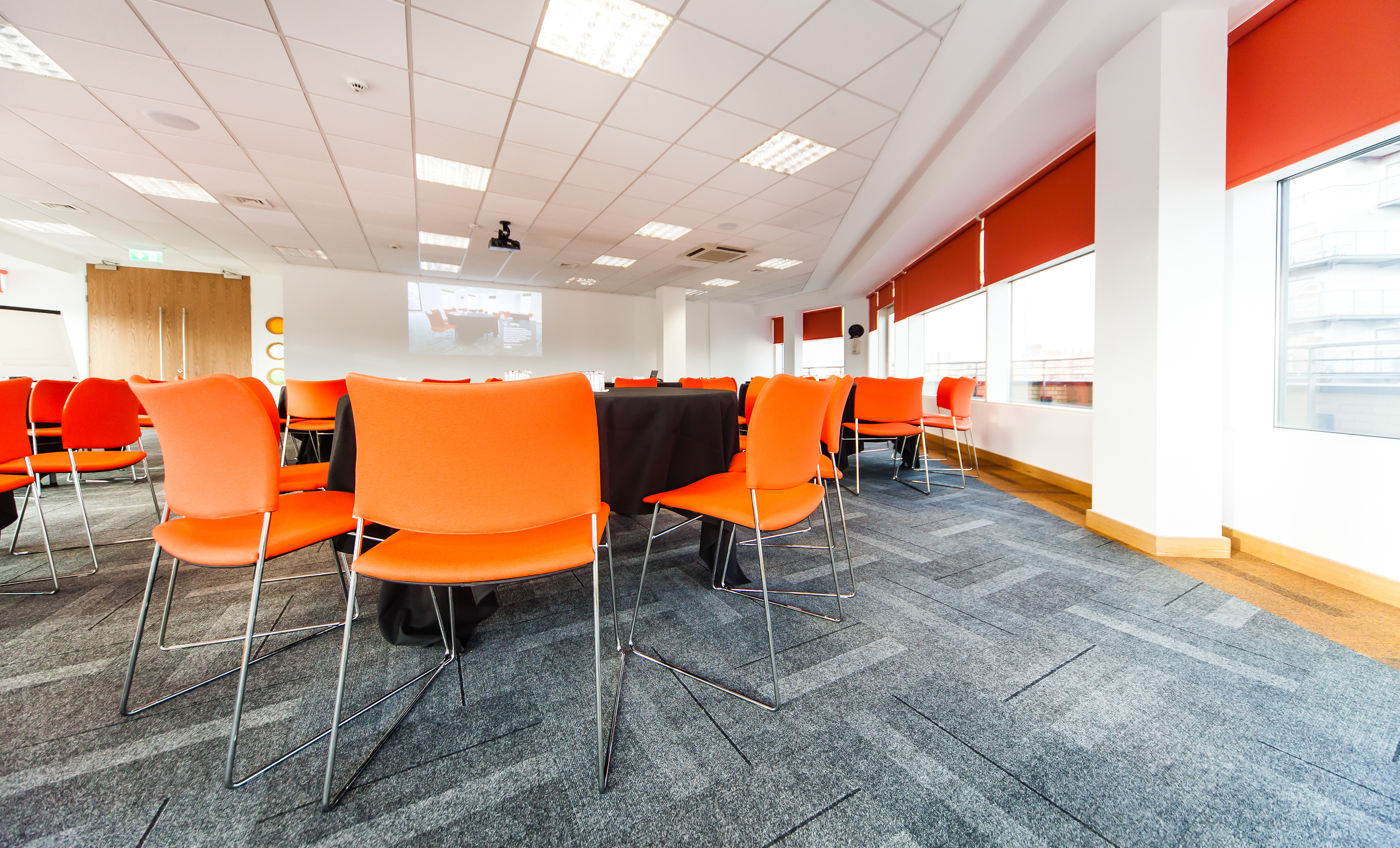 Modern meeting room in Leeds with orange chairs, ideal for collaborative events.