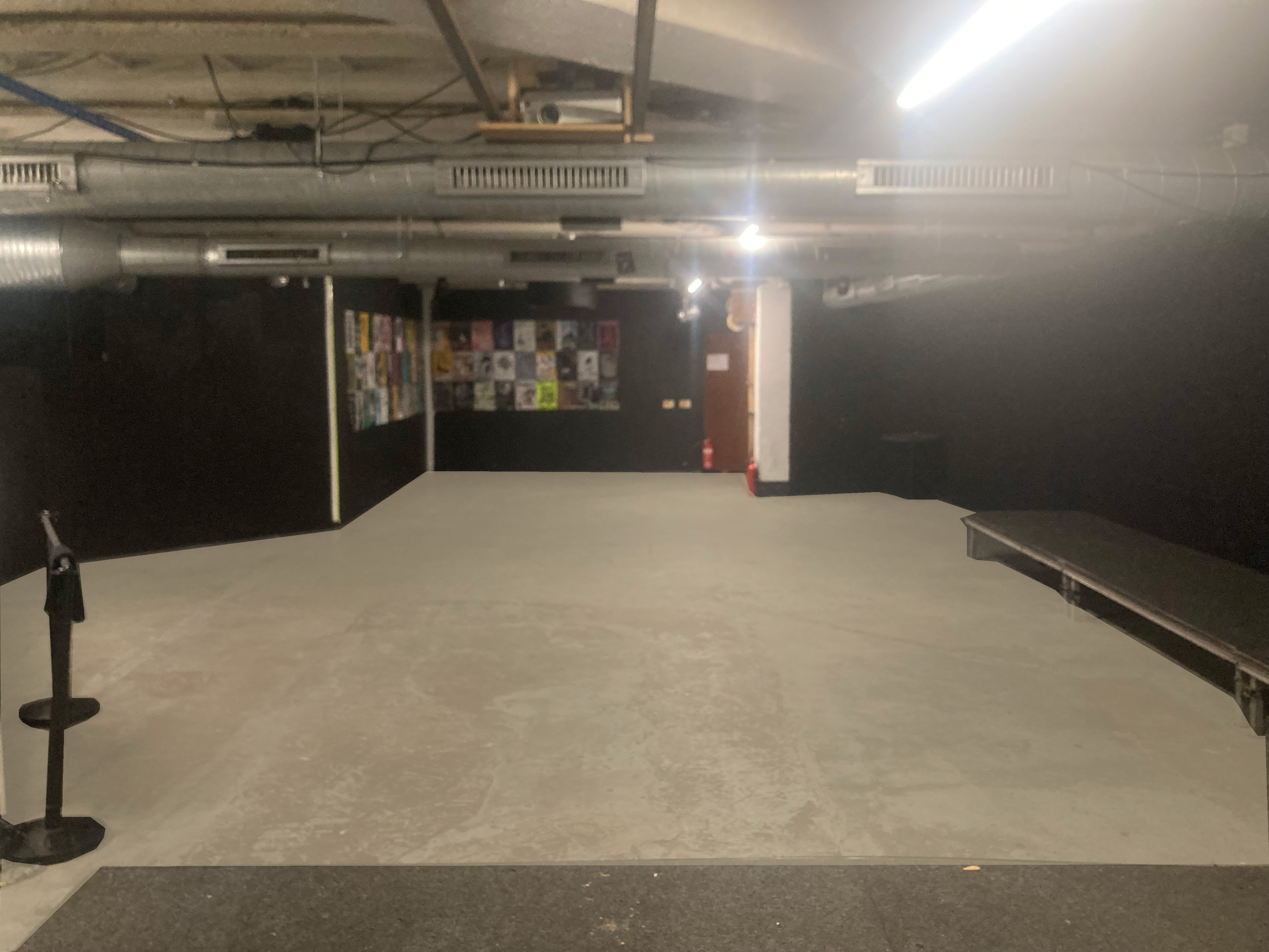 Versatile event space with black walls, ideal for presentations and performances.