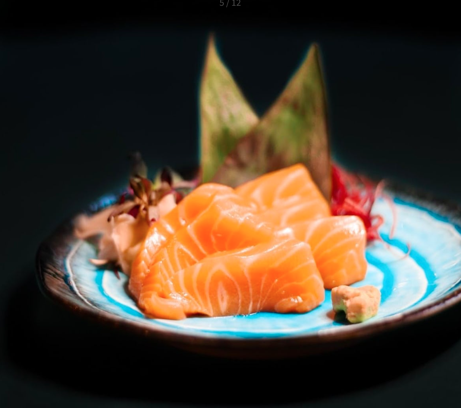 Vibrant salmon sushi on blue dish for upscale catering events and gatherings.