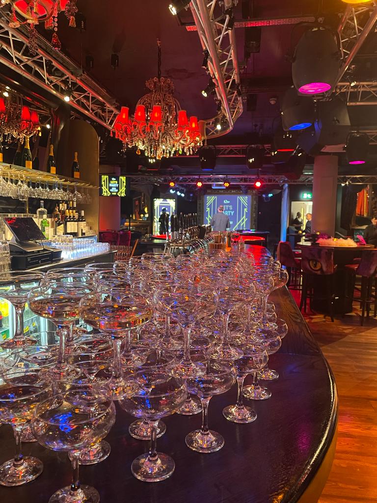 Stylish event space at Bartley's Lounge with elegant bar and champagne coupes for celebrations.