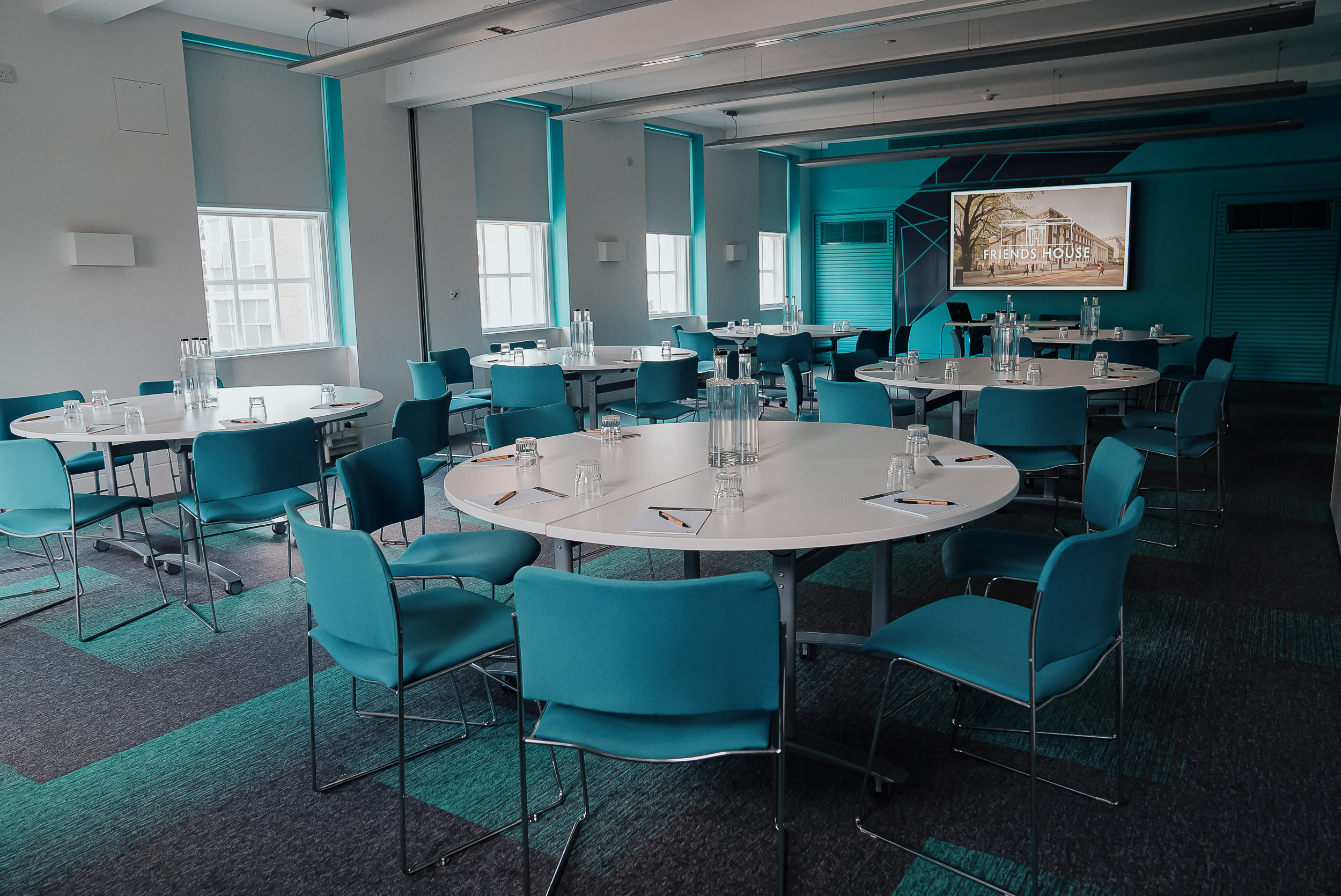 Modern meeting space with circular tables, ideal for workshops and corporate events.