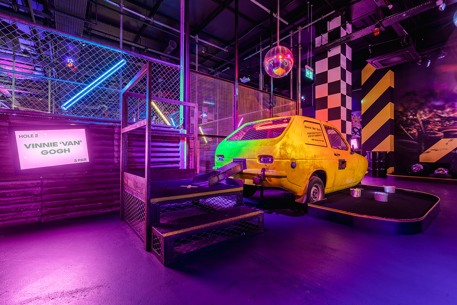 Vibrant Junkyard Golf Club with yellow car, neon lights for themed events and parties.