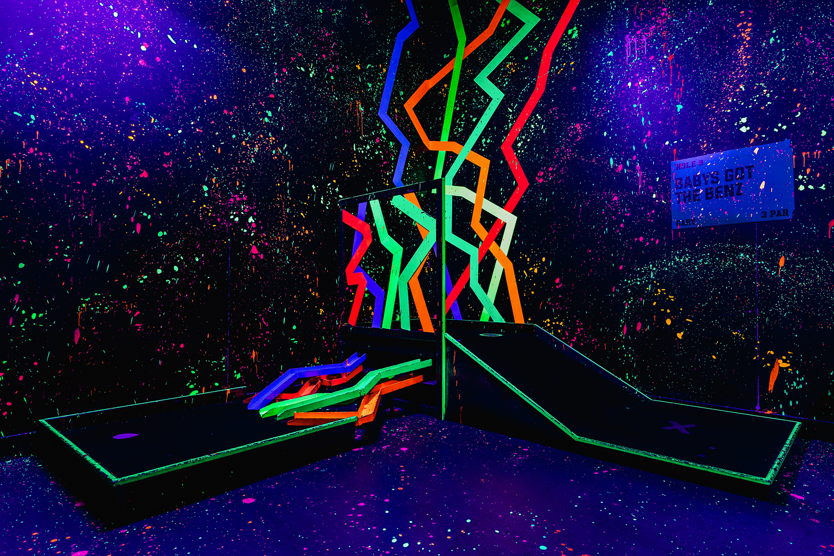 Gary enjoying neon-lit mini-golf at Junkyard Golf Club for team-building events.