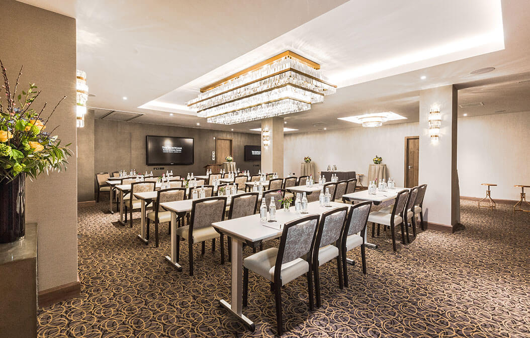 Sophisticated corporate meeting space with modern chandelier, ideal for workshops and presentations.