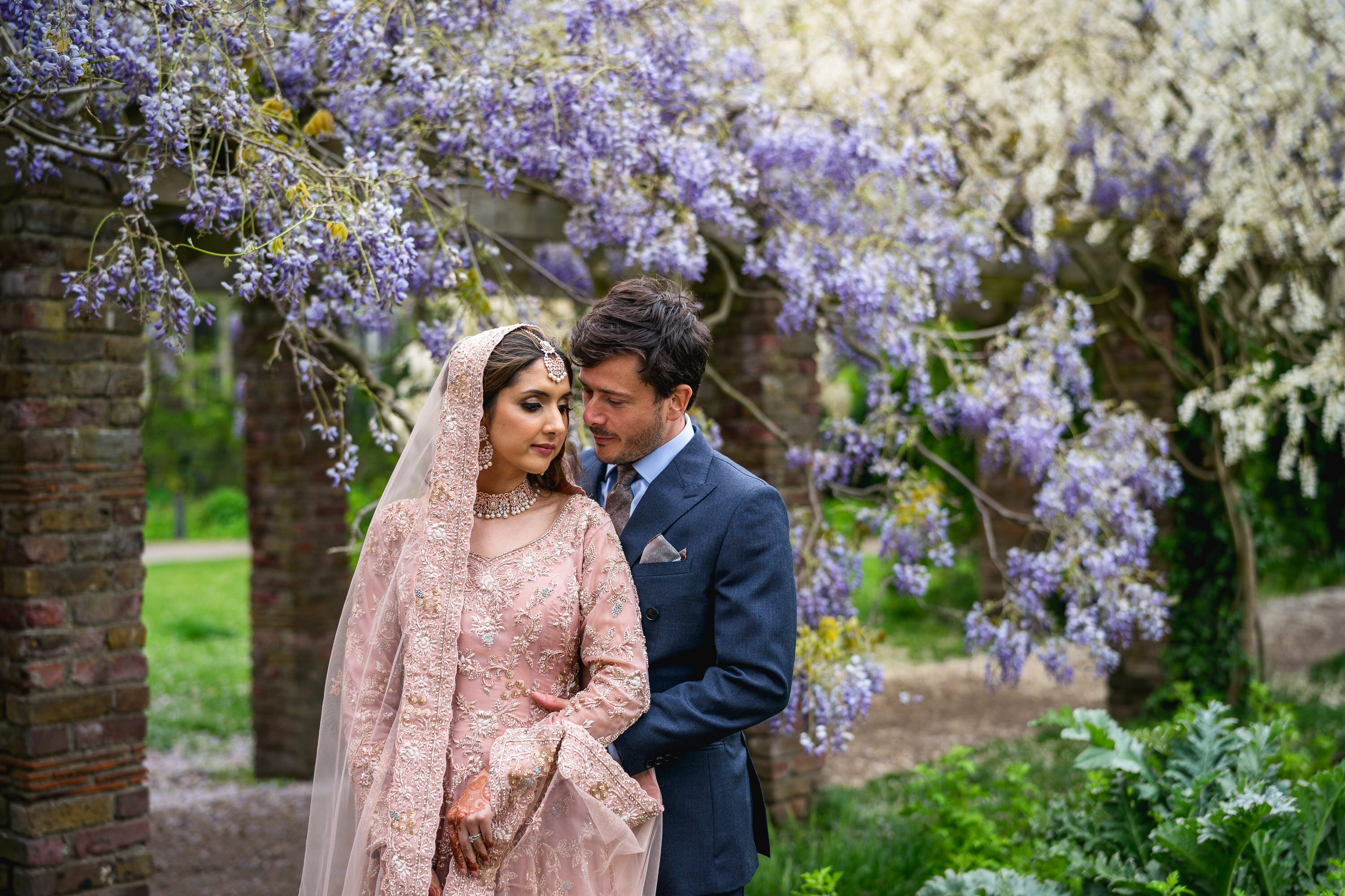 Couple under floral archway in Soane's Garden Room, ideal for weddings and romantic events.