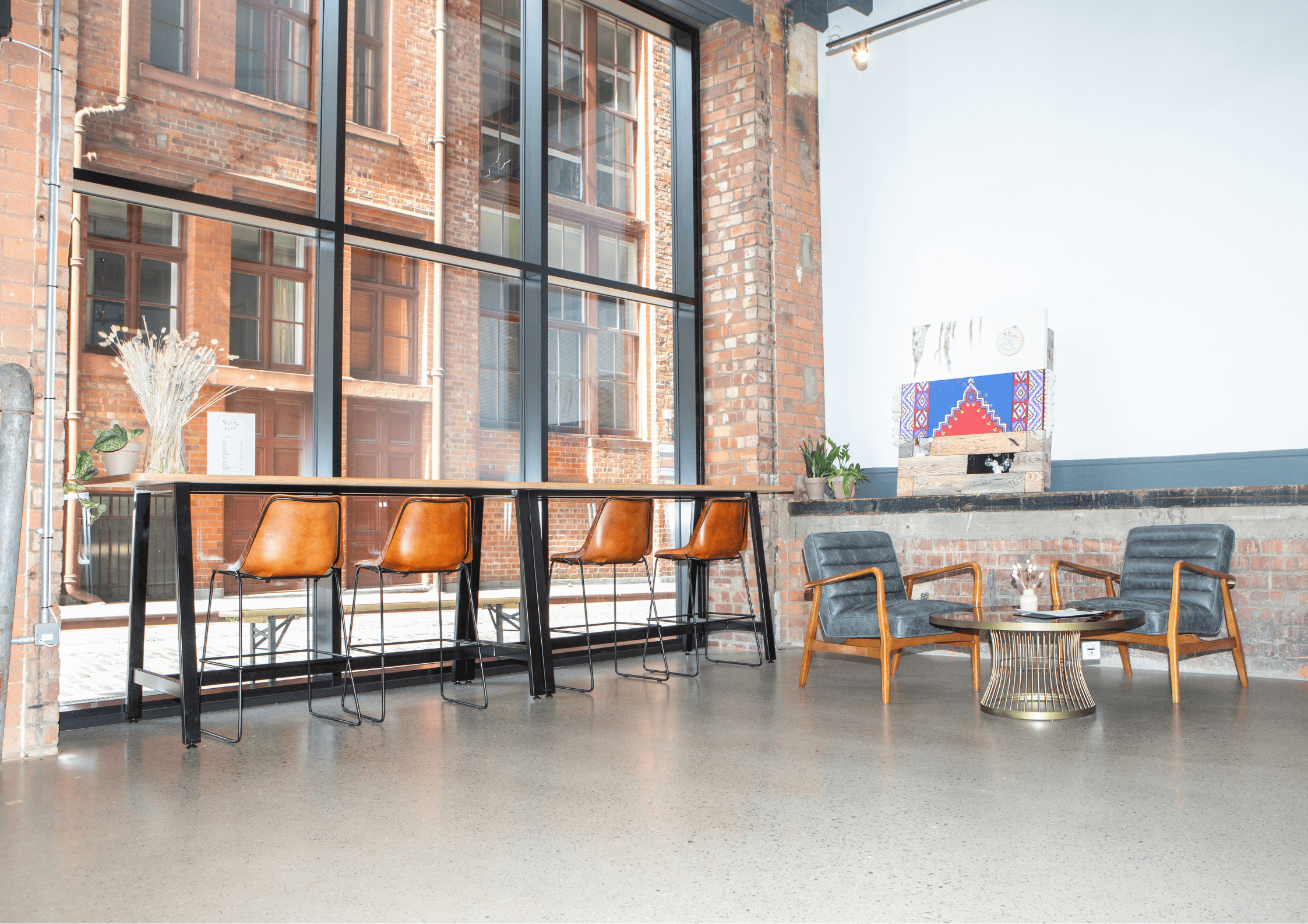 Modern industrial meeting space with large windows, ideal for networking and gatherings.