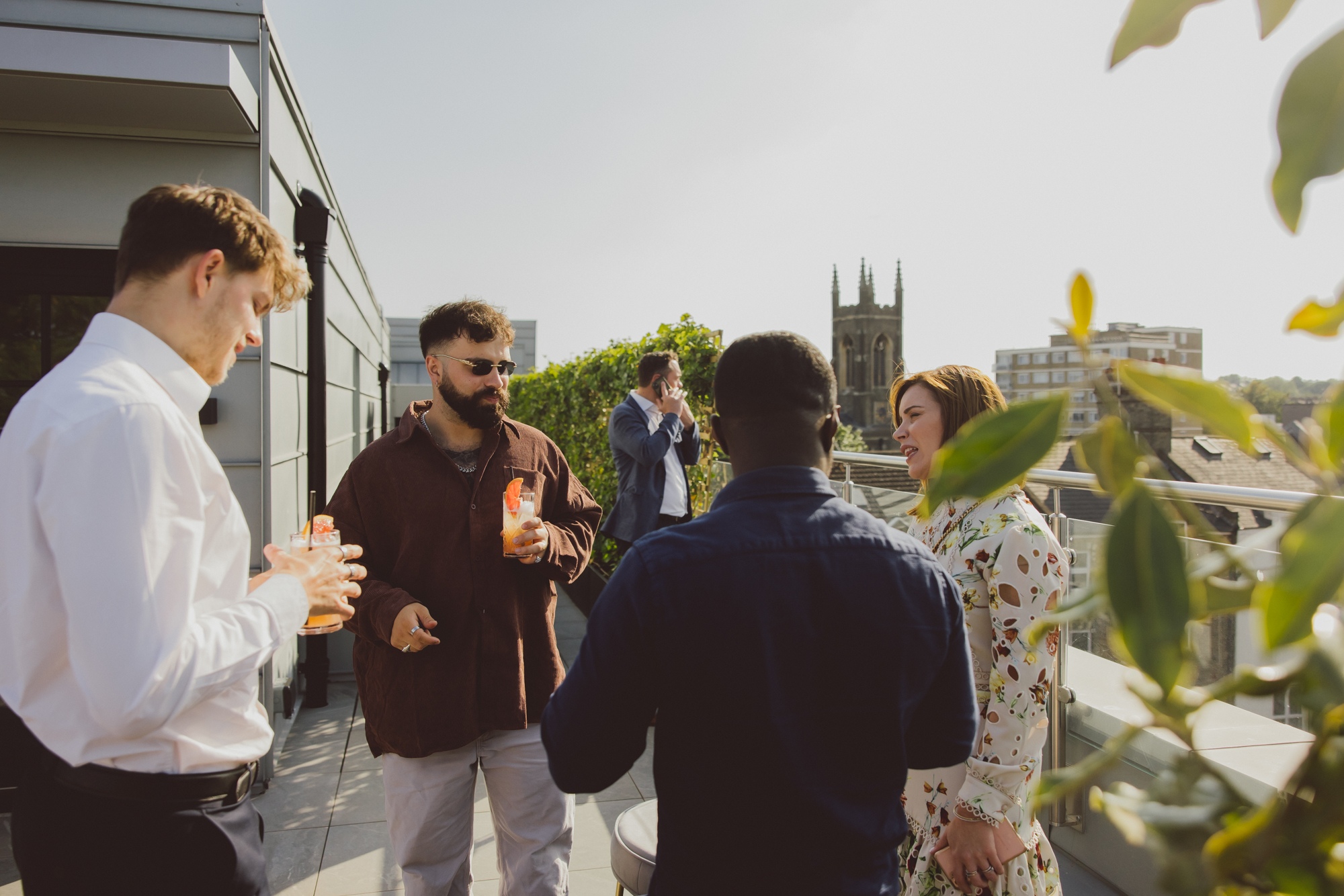 Vibrant rooftop networking event at Riley Studios with scenic backdrop and drinks.