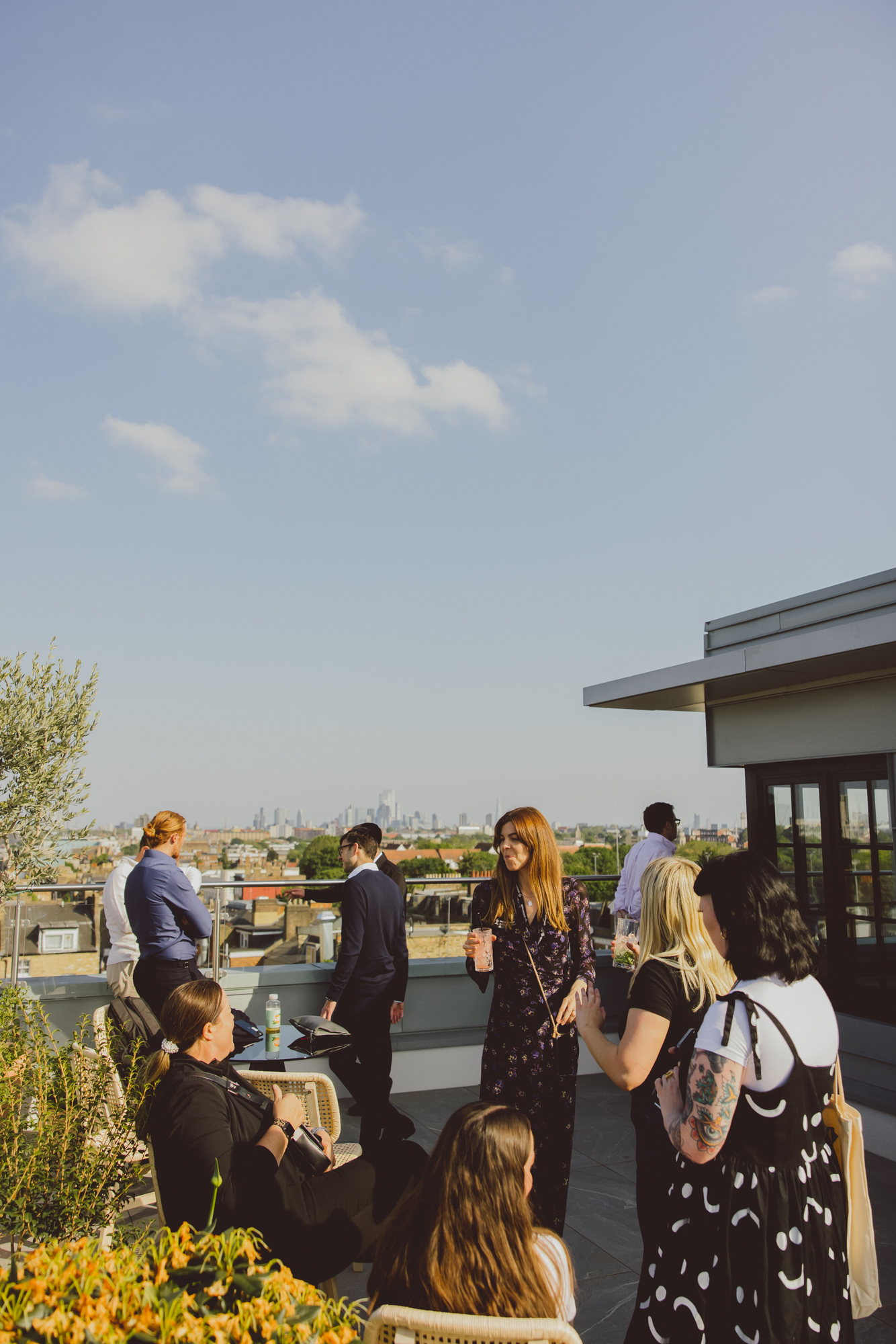 Vibrant rooftop networking event at Riley Studios with skyline backdrop.