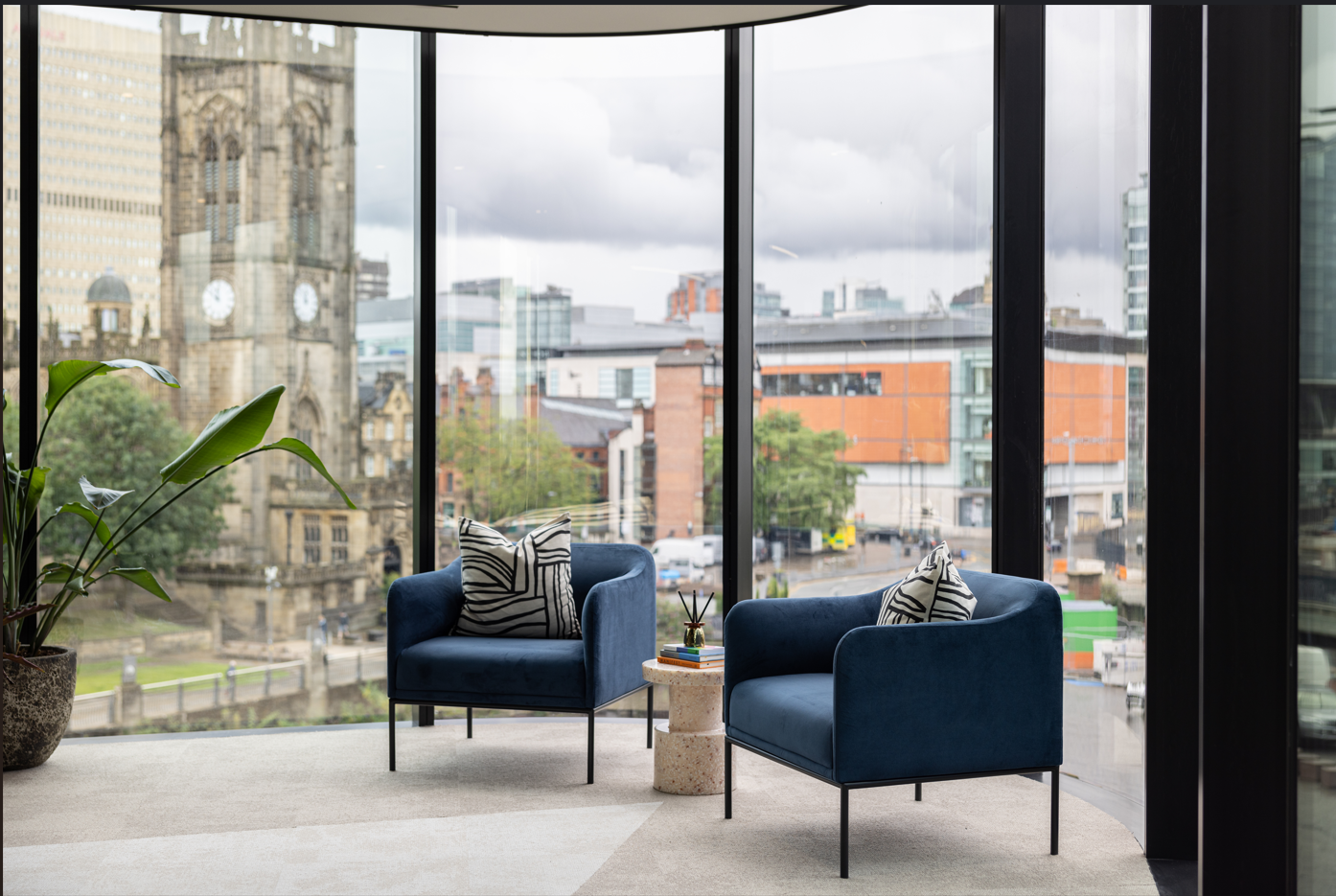 Modern meeting space with blue chairs and city views at x+why 100 Embankment.