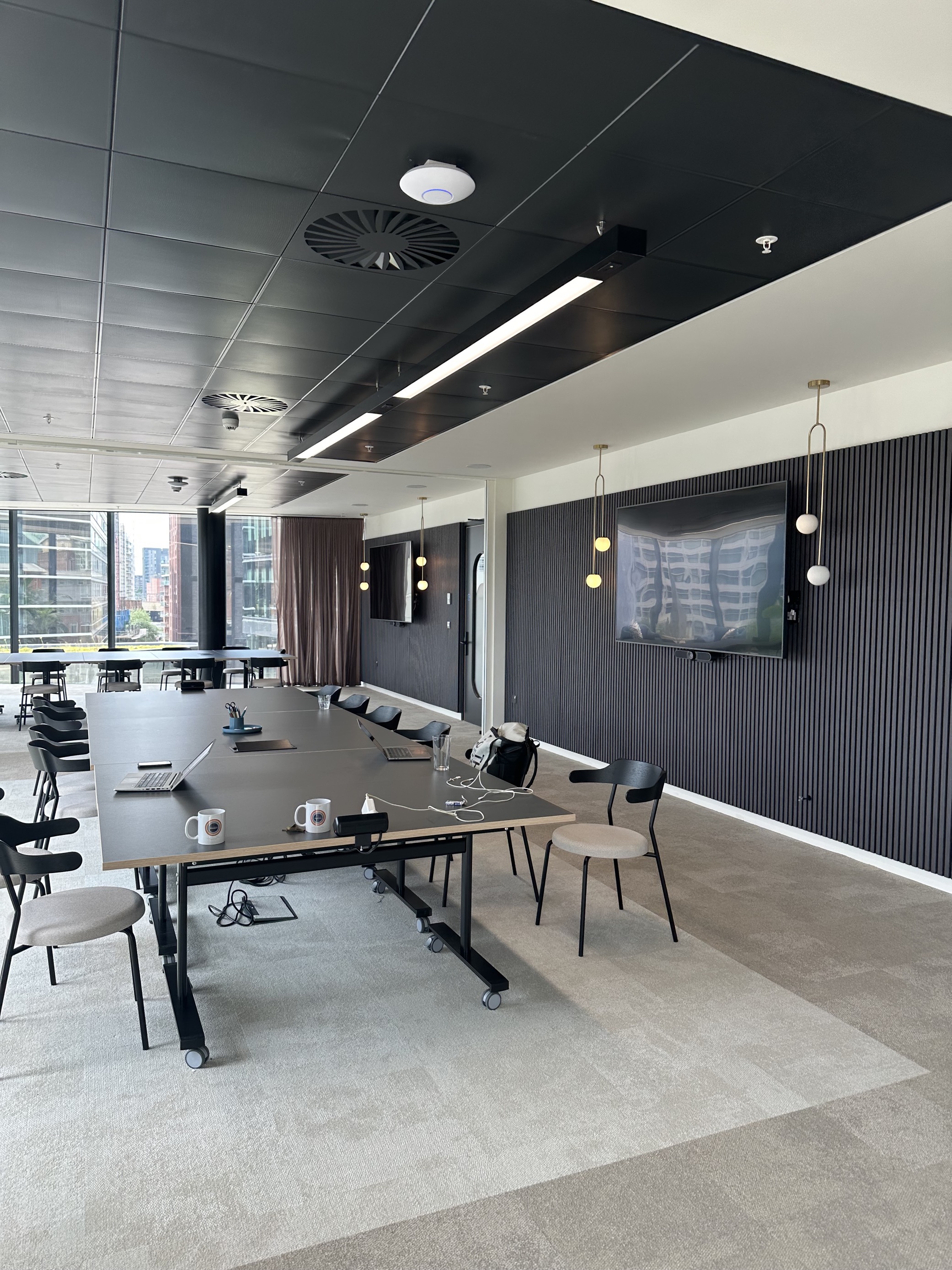 Modern meeting room with sleek table and screens for collaborative sessions at x+why.