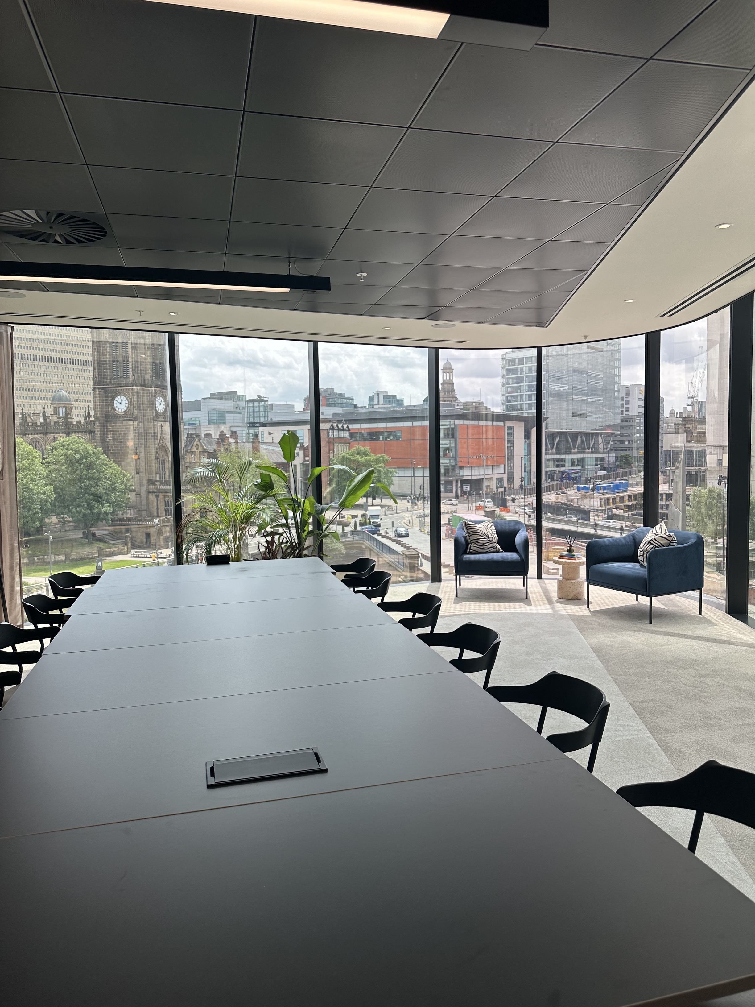 Modern meeting room with long table, city view, ideal for workshops and discussions.