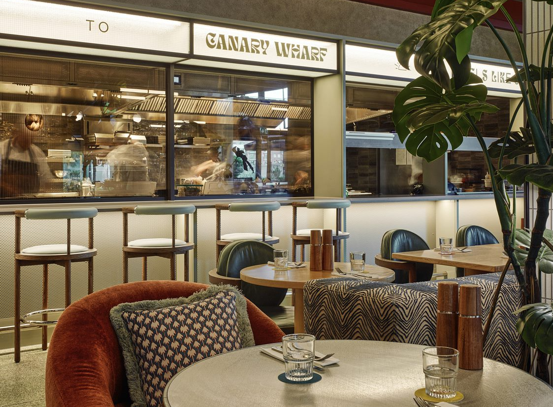 Modern dining space with open kitchen, perfect for casual meetings and upscale events.